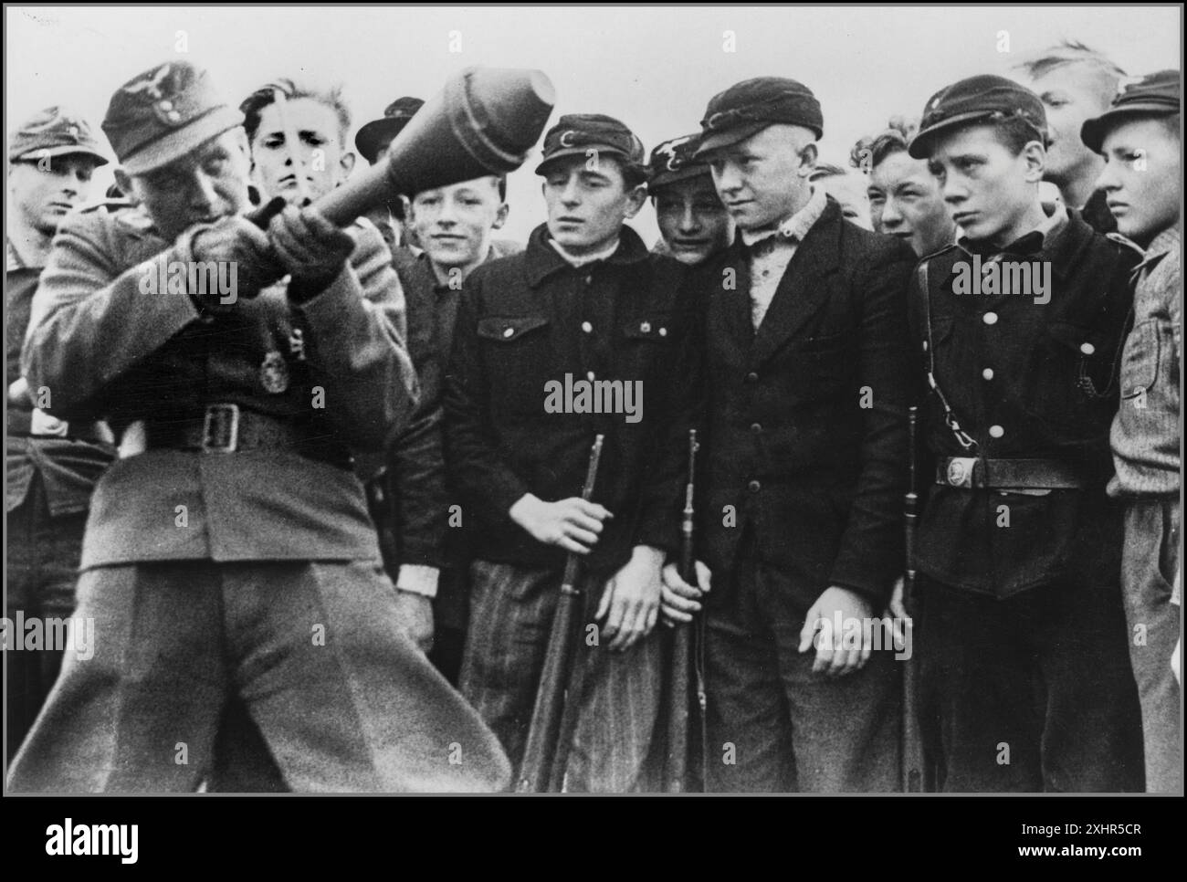 PANZERFAUST WW2 1945 soldato nazista della Wehrmacht dimostra il razzo anticarro Panzerfaust, ai ragazzi della Gioventù hitleriana, per addestrarli in un ultimo tentativo di frenare l'avanzata dell'esercito russo sovietico Berlino Germania nazista. Seconda guerra mondiale la battaglia di Berlino Foto Stock