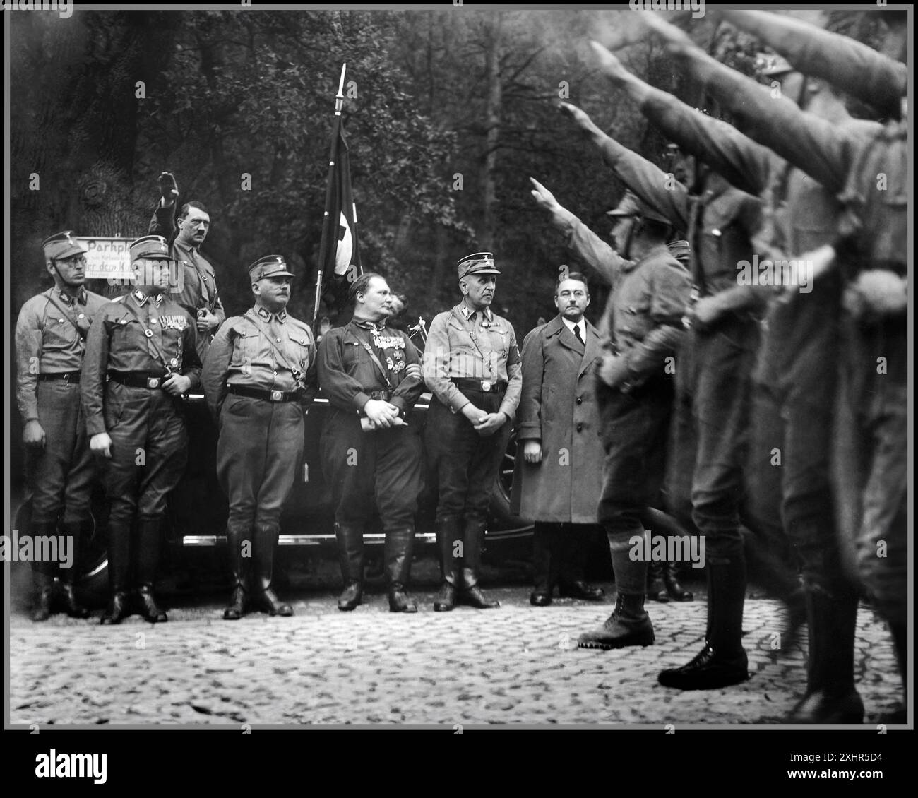 1931 Germania nazista la fondazione del fronte di Harzburg (in tedesco: Gründung der Harzburger Front). Foto scattata l'11 ottobre 1931 a Bad Harzburg che mostra: Sfilare le truppe delle SA (Sturmabteilung) salutando alcuni dei dirigenti della delegazione del Partito nazista (NSDAP) alla sessione congiunta dei diritti nazionali: Gerret Korsemann (1895–1958), in seguito generale delle SS e della polizia Viktor Lutze (1890–1943), rappresentante del Reichstag per Hannover-Braunschweig, in seguito leader delle SA (1934–1943) Adolf Hitler (1889–1945), leader del partito nazista Ernst Röhm (1887–1934), capo Sturmabteilung (SA) 1931–34 Hermann Göring (1893–1946), Foto Stock