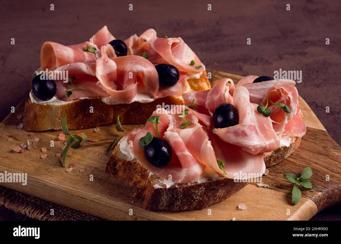 Fruehstueck, Speck- und Oliven-Sandwich, auf einem Schneidebrett, Draufsicht, Nahaufnahme, Keine Personen Foto Stock