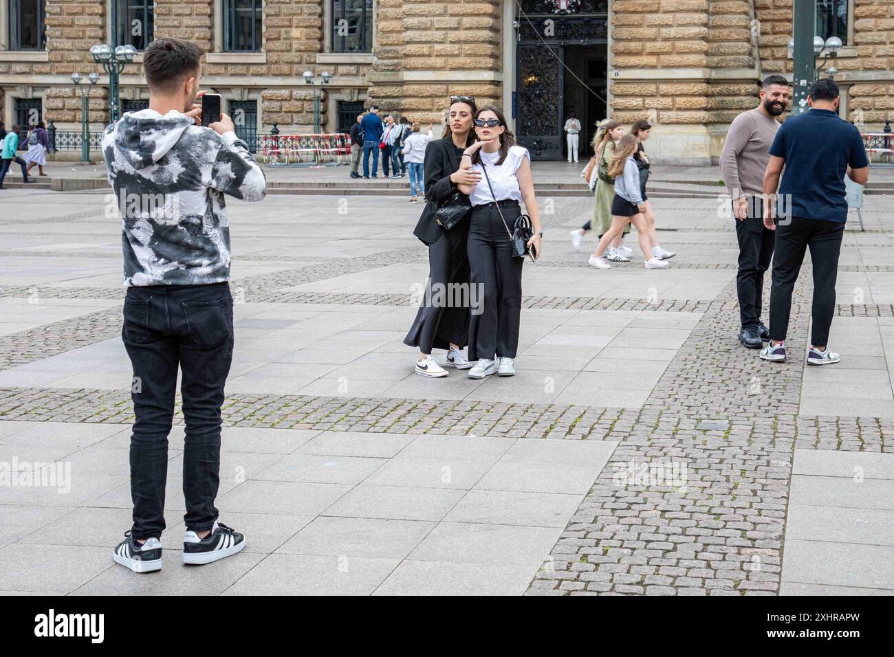 Giovani donne in posa per una foto in piazza Rathausmarkt nel quartiere Altstadt di Amburgo, Germania Foto Stock