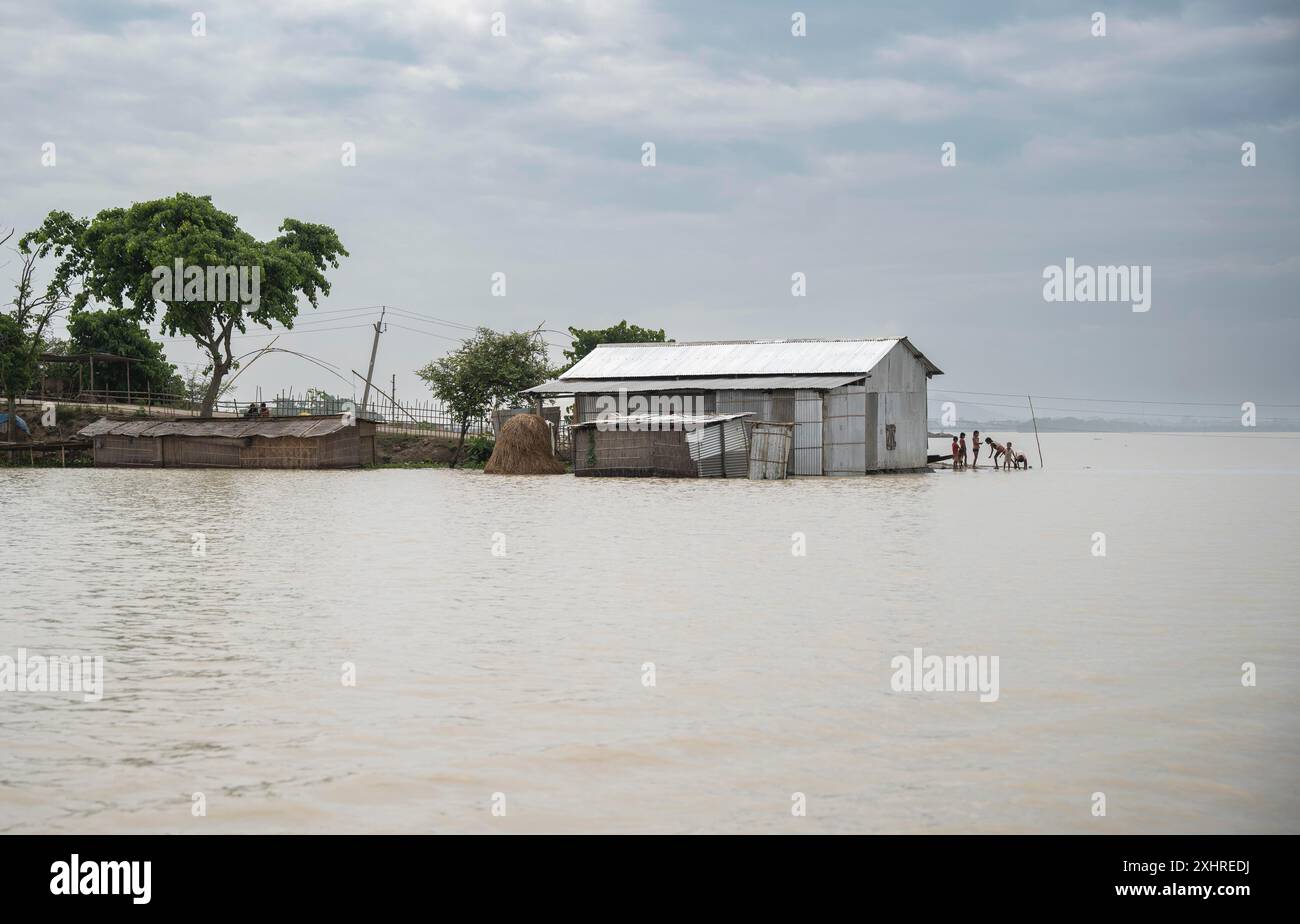 Morigaon, India. 4 luglio 2024. Un insediamento è parzialmente sommerso in un'inondazione nel distretto di Morigaon, nello stato nordorientale dell'India, Assam, il 4 luglio Foto Stock