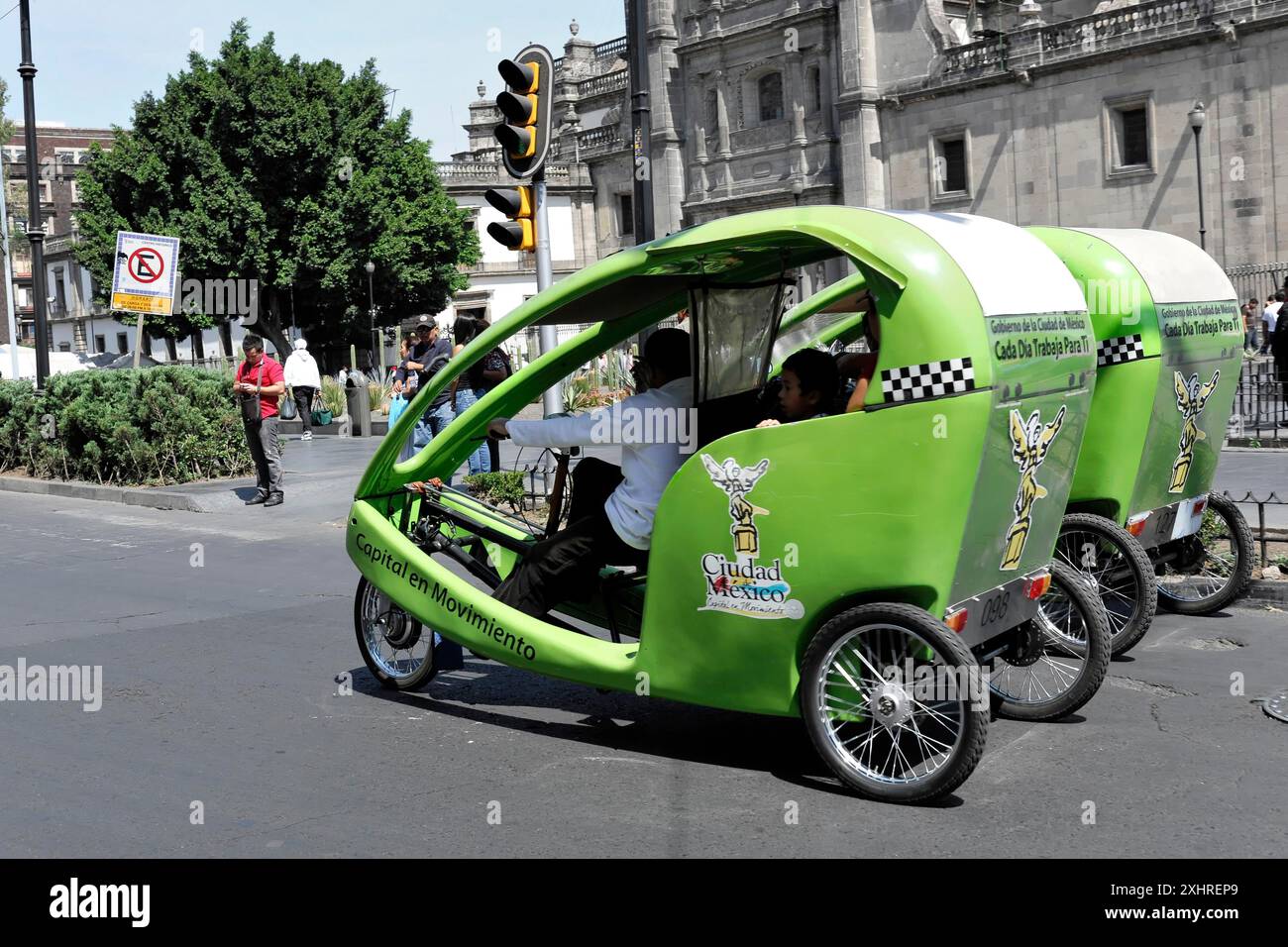 Città del Messico, Messico, America centrale, tre risciò verdi in una città vivace. Edifici e alberi possono essere visti sullo sfondo Foto Stock