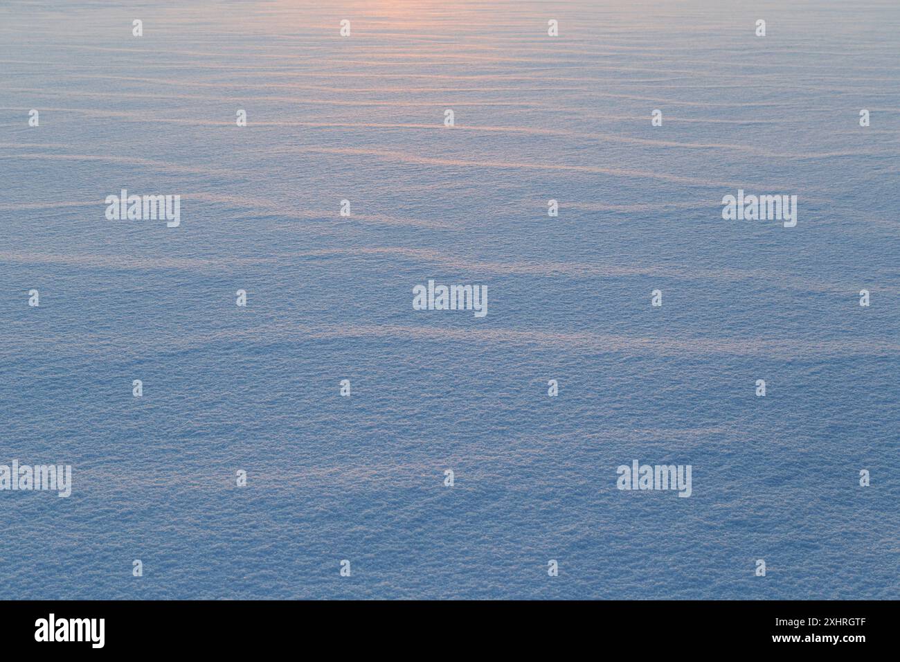 Paesaggio di neve fresca e pulita a terra al tramonto. Ottimo come sfondo naturale della stagione invernale con spazio per le copie. Bellissime forme astratte innevate. Foto Stock