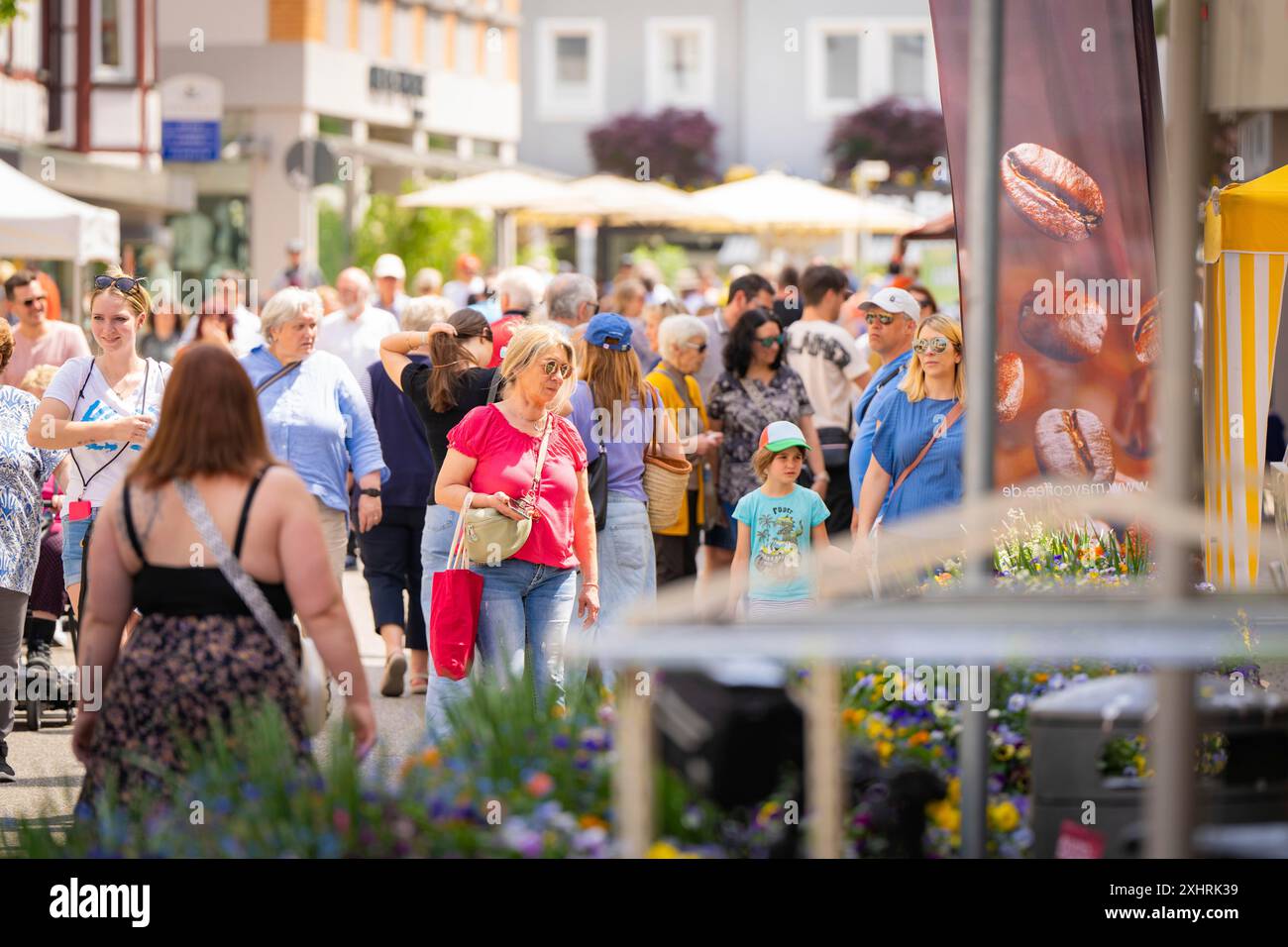 Mercato di strada affollato con molta gente, tempo soleggiato e uno striscione di caffè circondato da fiori e alberi, fiera del giardino e ceramiche, Nagold Foto Stock