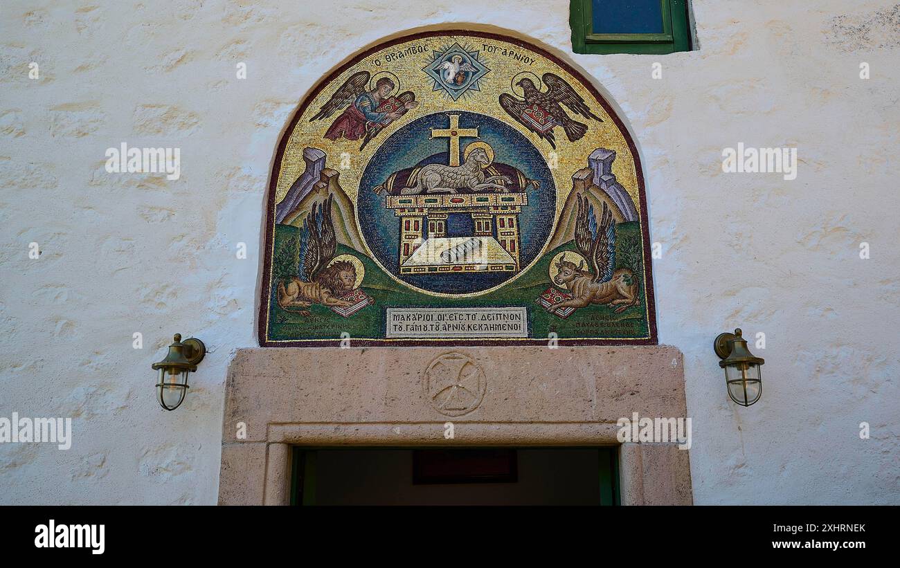 Un dettagliato mosaico religioso sopra un'entrata, incorniciato da muri in pietra e apparecchi di illuminazione, Monastero tis Apokalipsis, Patmos, Dodecaneso, greco Foto Stock