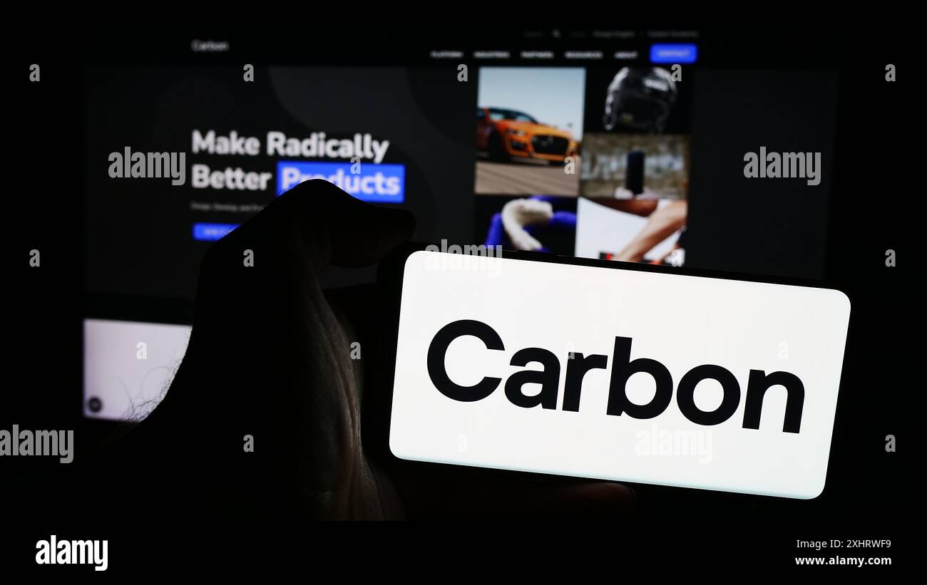 Persona che detiene un telefono cellulare con il logo della società americana di stampa 3D Carbon Inc. Davanti alla pagina Web aziendale. Mettere a fuoco il display del telefono. Foto Stock