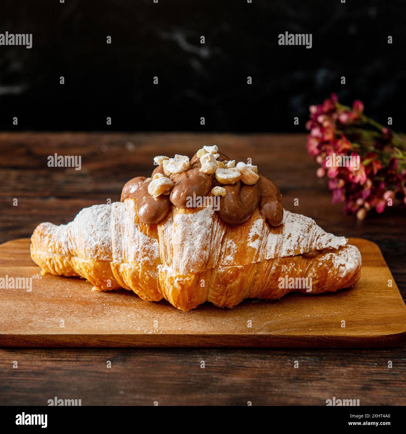 Croissant al cioccolato appena sfornati su sfondo di legno. Foto Stock