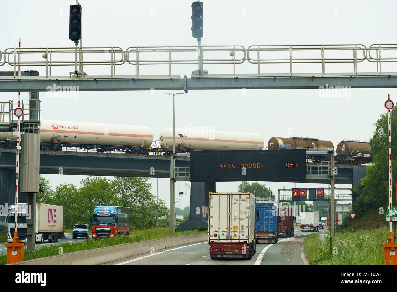 Gent, Belgio - 22 maggio 2023: Enormi pale di turbine eoliche trasportate su un carro di carico pesante lungo un'autostrada, passando sotto una limitazione di altezza Foto Stock