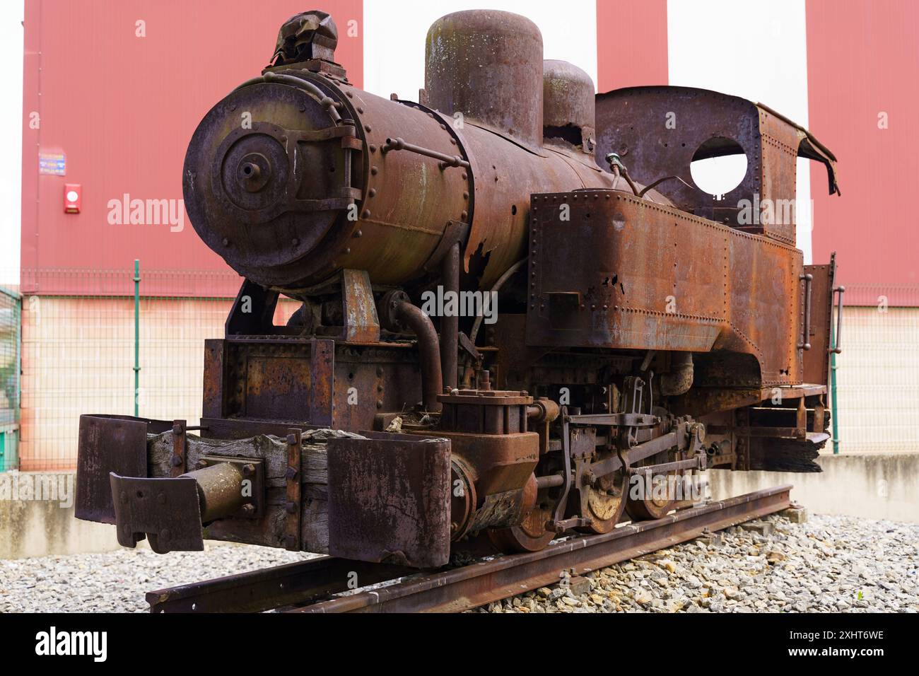 Una locomotiva a vapore arrugginita e inattiva è inattiva su una pista, la sua gloria sbiadita lascia intendere un'era ormai passata dell'industria. Foto Stock