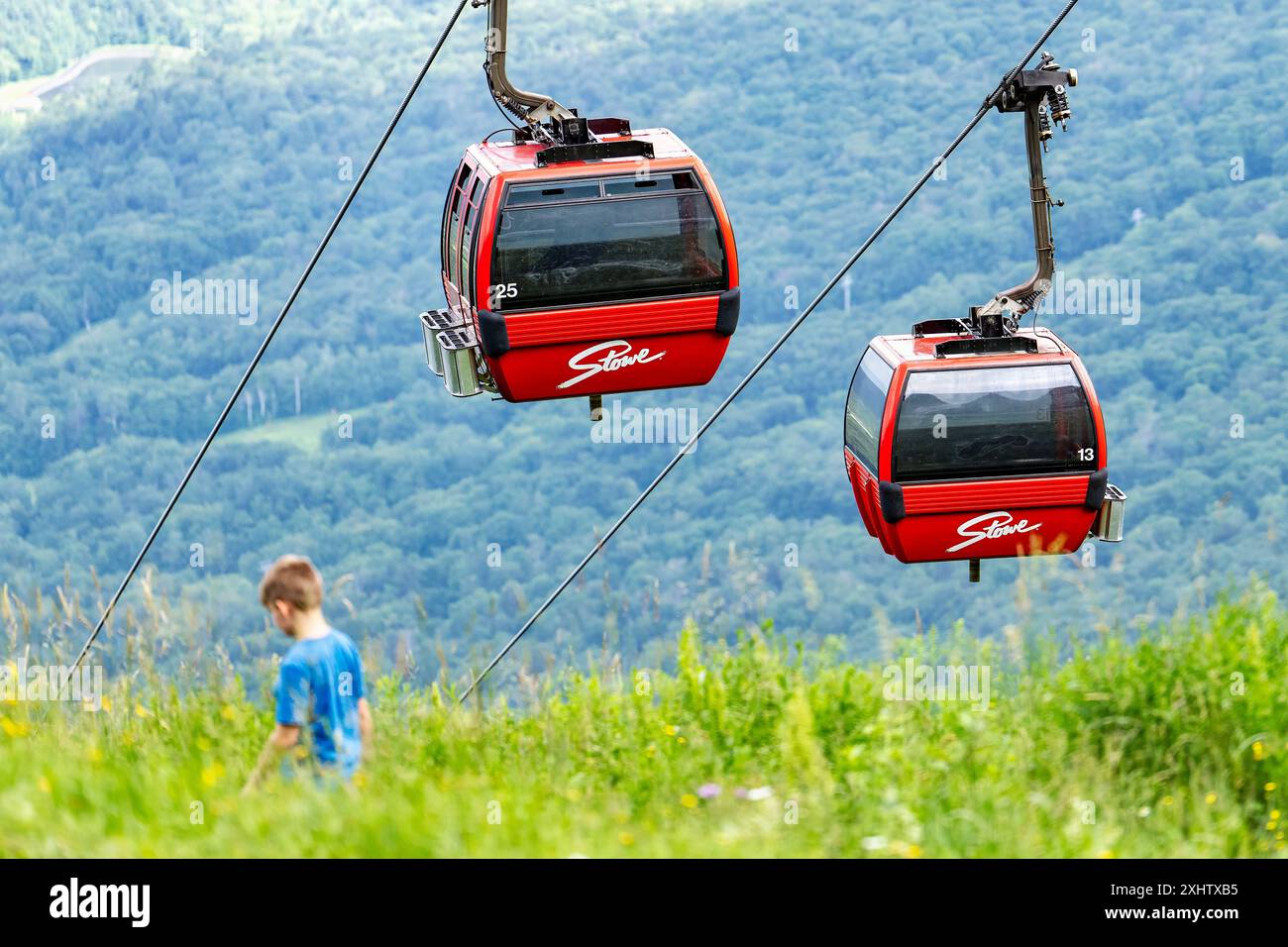 Stowe, Vermont, Stati Uniti. 15 luglio 2024. Un bambino passeggia davanti a una funivia dello Stowe Mountain Resort a Stowe, Vermont, il 15 luglio 2024. (Immagine di credito: © Ronen Tivony/ZUMA Press Wire) SOLO PER USO EDITORIALE! Non per USO commerciale! Foto Stock