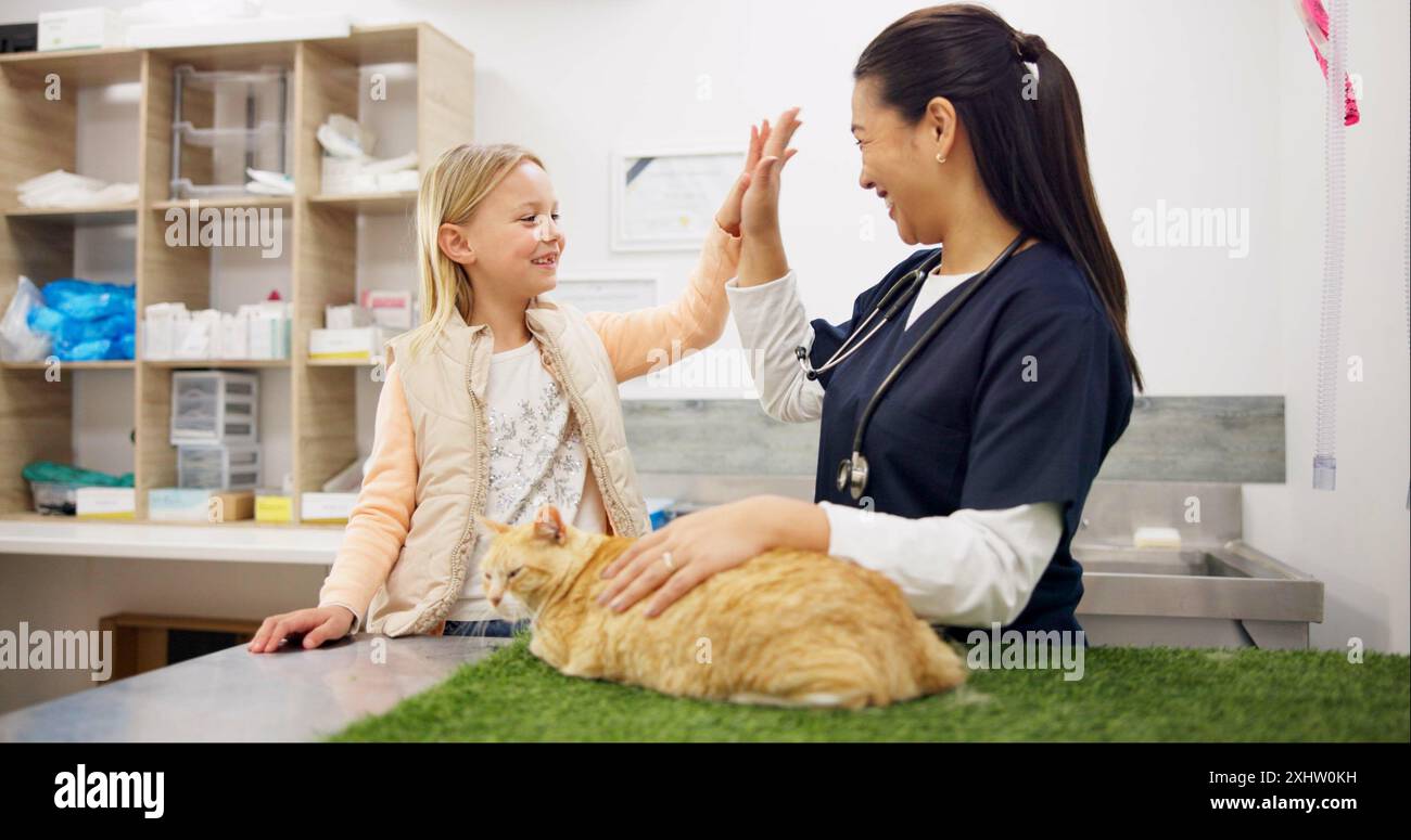 Medico, bambino e alto cinque per la salute in clinica con il benessere del gatto, successo e celebrazione di servizi animali. Sorridi, veterinario e ragazza con gattino per Foto Stock