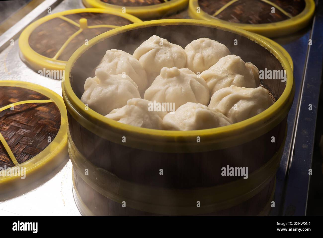 Vaporiera di bambù con baozi. Panini al vapore ripieni cinesi. All'interno della cucina del ristorante. bun Pao-tsih. Bao. Foto Stock