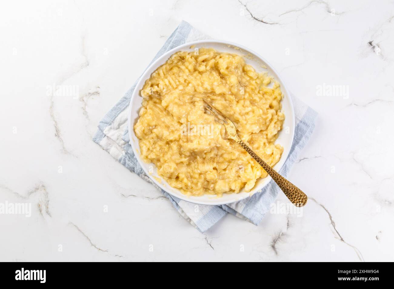 Amalgamare la banana con la forchetta, preparare la torta alla banana Foto Stock
