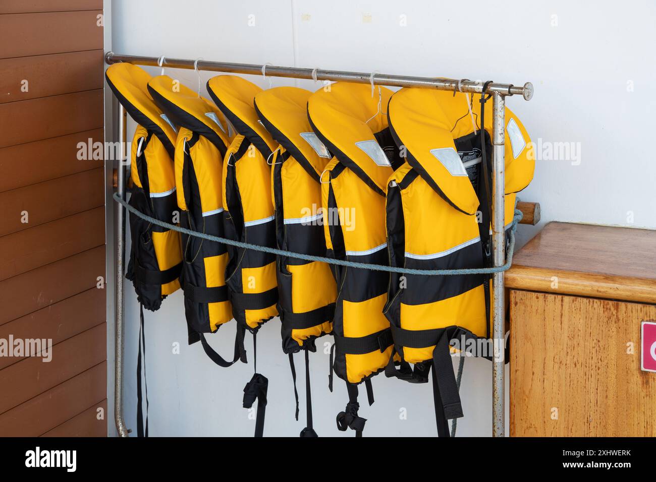 In mare, Oceano Pacifico - 21 marzo 2019: Una fila ordinata di giubbotti di salvataggio pronti per la sicurezza dei passeggeri a bordo di una nave da crociera. Foto Stock