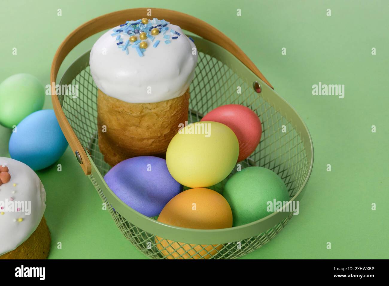 Torta di Pasqua e uova in un cestino. Sfondo verde. Foto Stock