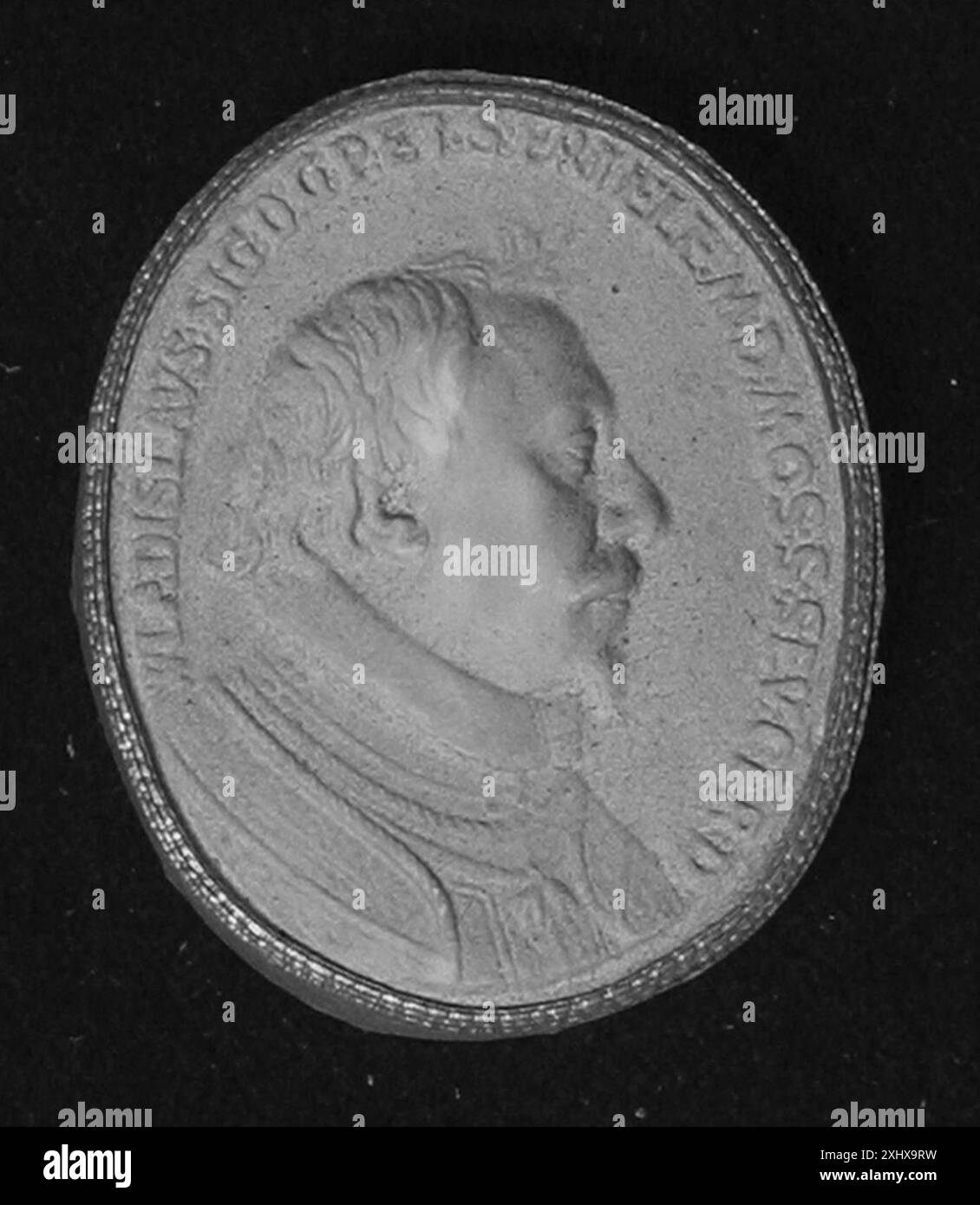 Oggetto di tipo incerto che potrebbe essere una medaglia, un sigillo o una moneta, che presenta forma circolare, un disegno a rilievo, iscrizioni e caratteristiche dei materiali metallici. Foto Stock