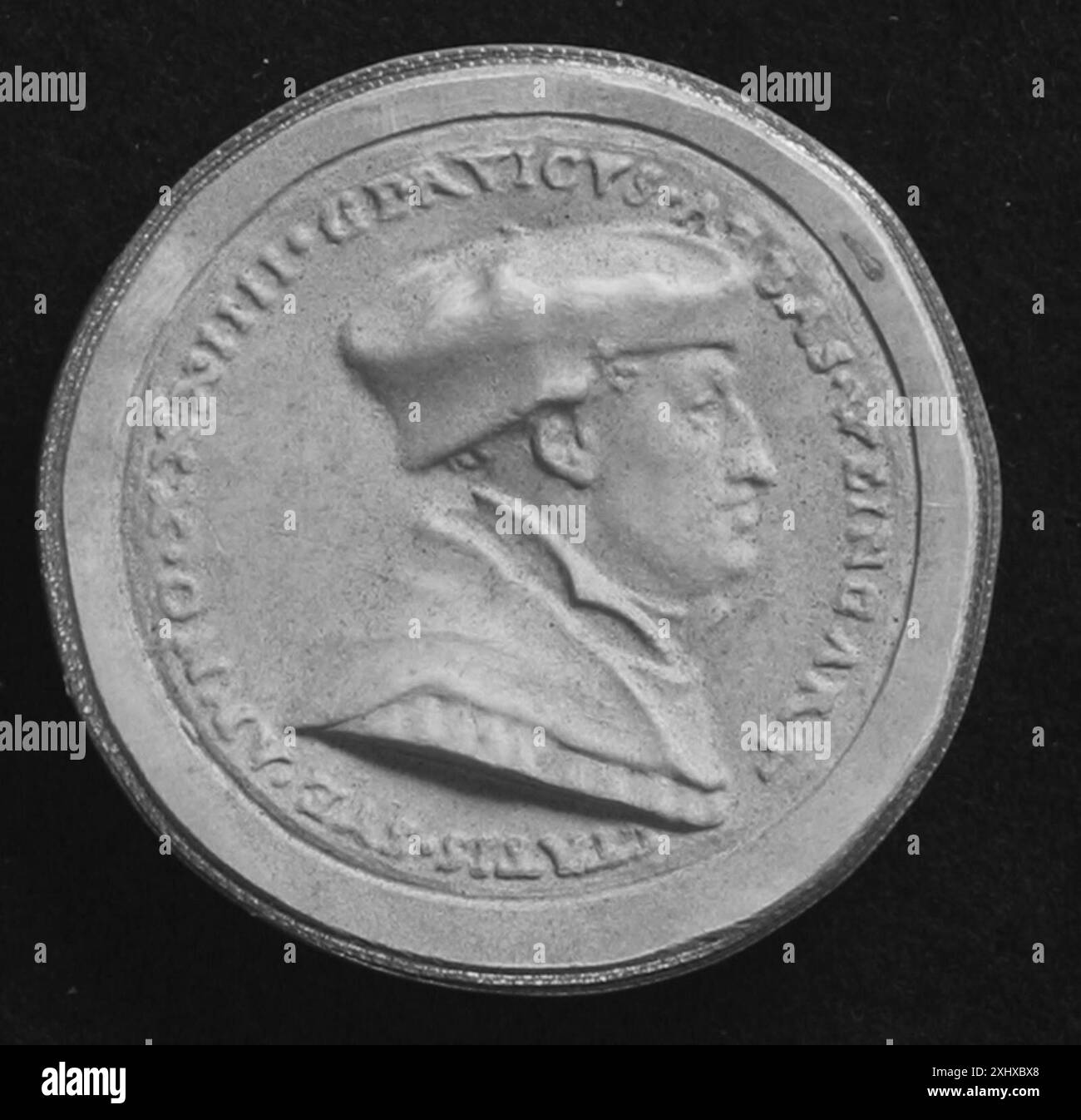 Artefatto circolare di tipo sconosciuto, eventualmente medaglia, sigillo o moneta, che ponga l'accento sul rilievo, motivi incisi e superficie metallica. Foto Stock