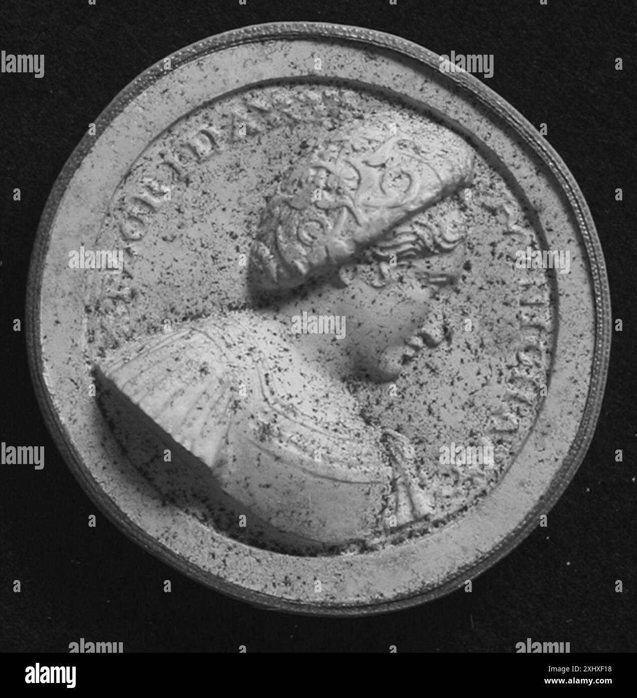 Un oggetto metallico di tipo indeterminato, eventualmente una medaglia, un sigillo o una moneta, che espone opere di rilievo, ripetizioni incise e simmetria circolare. Foto Stock