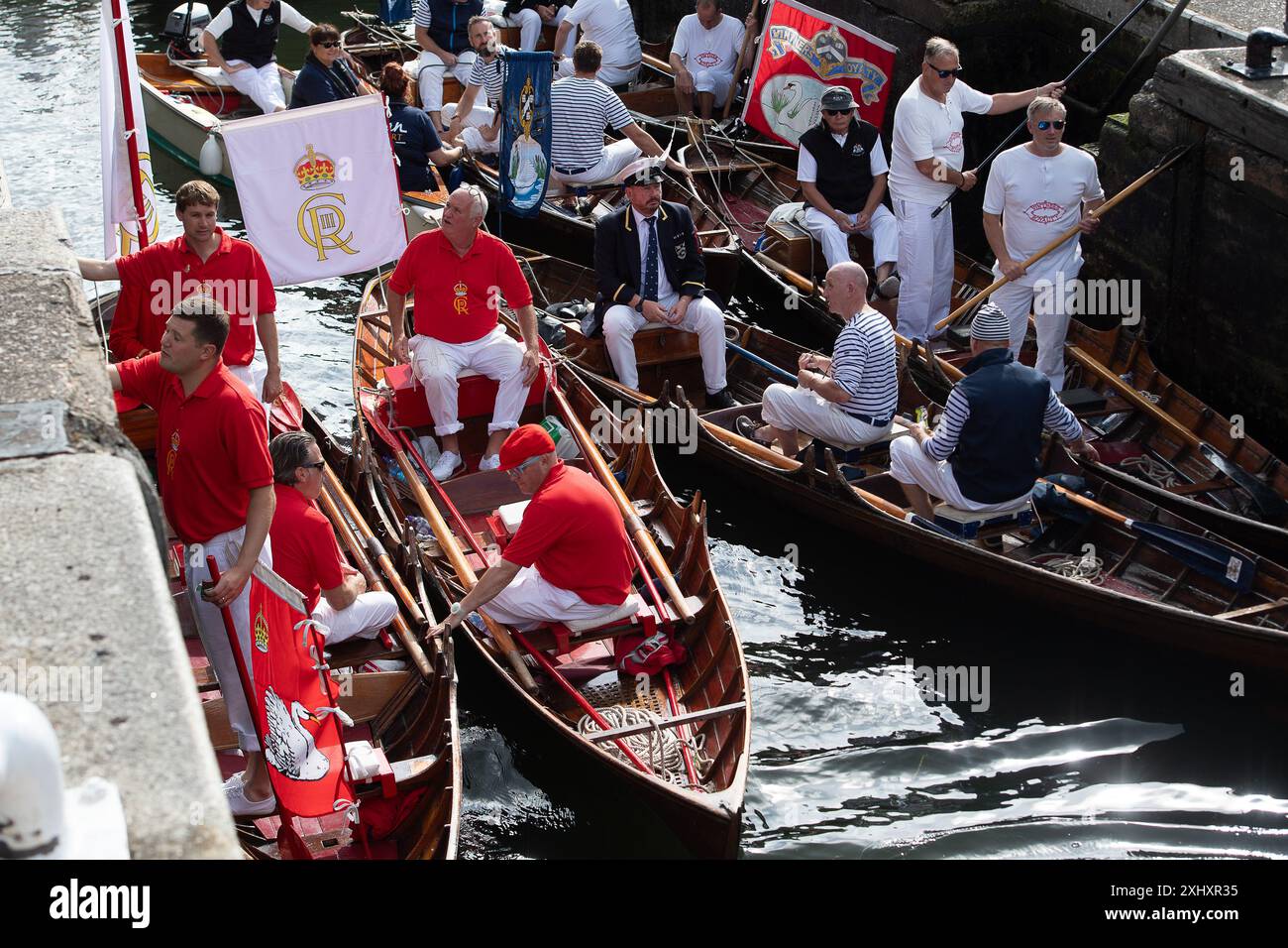 Boveney, Buckinghamshire, Regno Unito. 16 luglio 2024. Questa settimana sul Tamigi si svolge l'annuale Swan upping. HM le tomaie del cigno del re e le tomaie del cigno della Dyers Livery e della Vintners Livery erano al Boveney Lock nel Buckinghamshire questa mattina, dove hanno incontrato i bambini delle scuole locali per parlare loro della crescita del cigno. Durante il censimento annuale di questa settimana, i cigni superiori conteranno il numero di cigni e cignetti e controlleranno la loro salute. Crediti: Maureen McLean/Alamy Live News Foto Stock