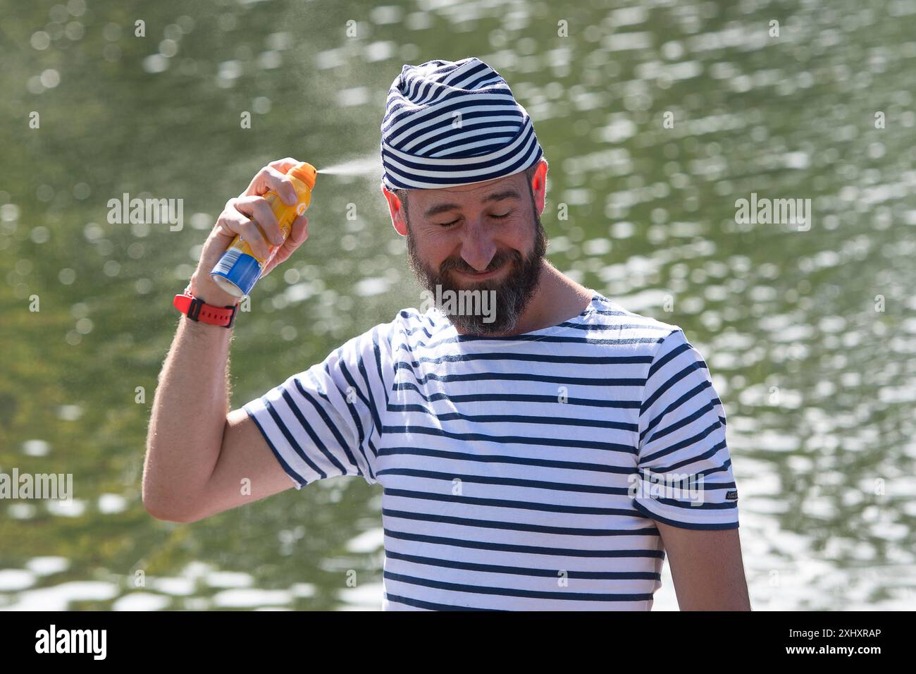 Boveney, Buckinghamshire, Regno Unito. 16 luglio 2024. Una Swan Upper spruzza sulla lozione abbronzante. Questa settimana sul Tamigi si svolge l'annuale Swan upping. HM le tomaie del cigno del re e le tomaie del cigno della Dyers Livery e della Vintners Livery erano al Boveney Lock nel Buckinghamshire questa mattina, dove hanno incontrato i bambini delle scuole locali per parlare loro della crescita del cigno. Durante il censimento annuale di questa settimana, i cigni superiori conteranno il numero di cigni e cignetti e controlleranno la loro salute. Crediti: Maureen McLean/Alamy Live News Foto Stock