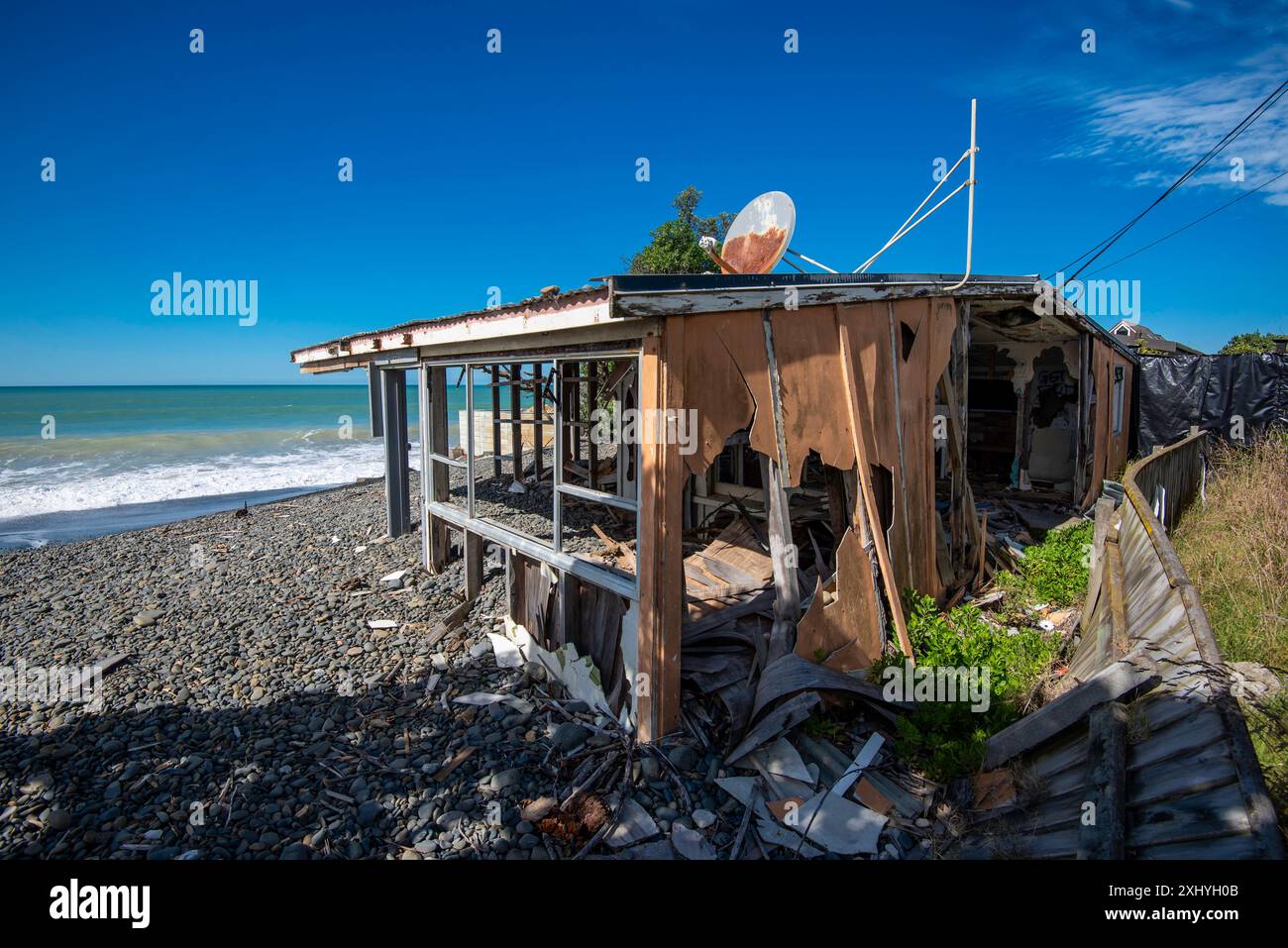 Un Batch (casa per le vacanze o cottage) su una spiaggia vicino a Cape Kidnappers nell'Isola del Nord della nuova Zelanda, distrutto dal ciclone Gabrielle nel febbraio 2023 Foto Stock