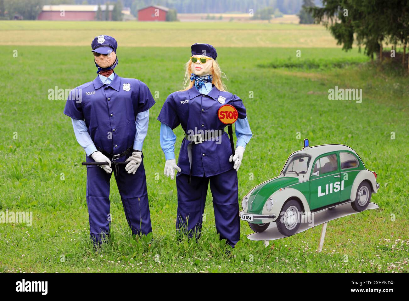 Accordo umoristico con figure di polizia maschili e femminili e una foto di un'auto della polizia speciale Volkswagen. Salo, Finlandia. 13 luglio 2024. Foto Stock