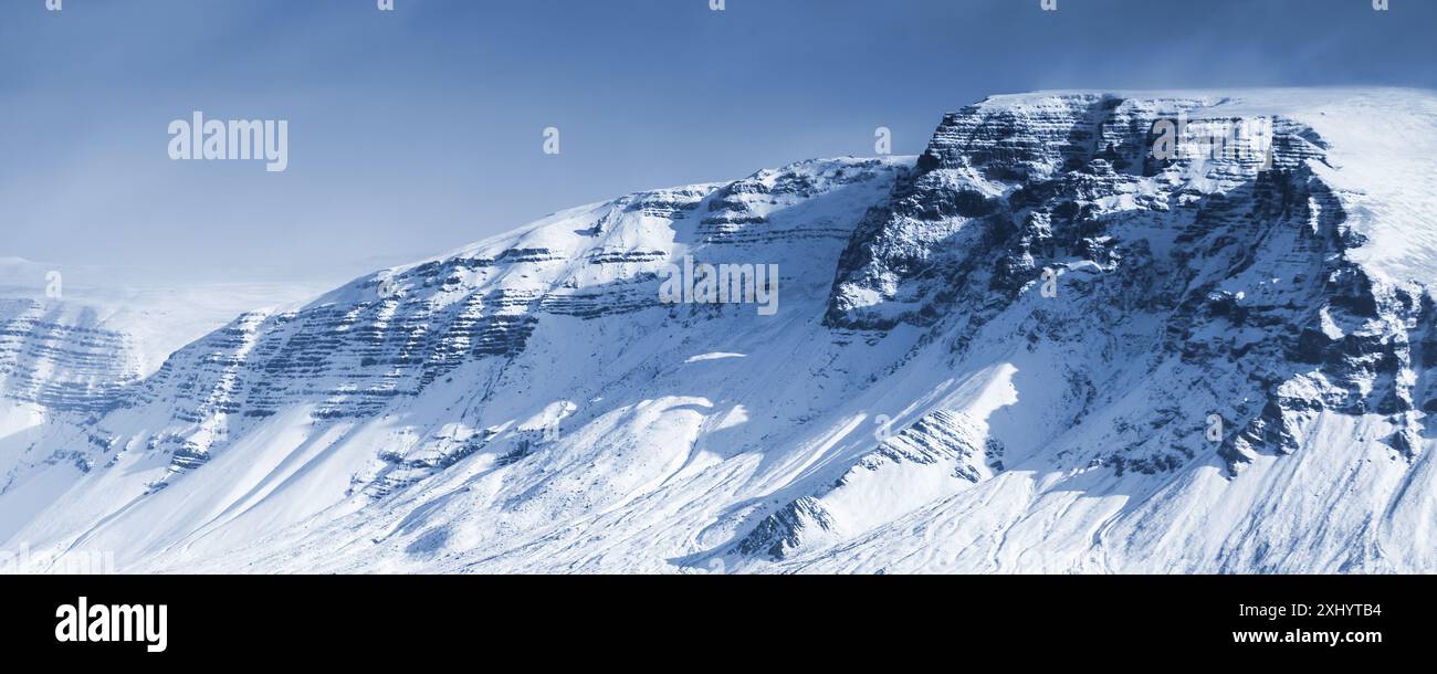 Paesaggio islandese con montagne innevate sotto il cielo blu. Area di Reykjavik, Islanda. Foto panoramica con effetto filtro di correzione del tono blu Foto Stock