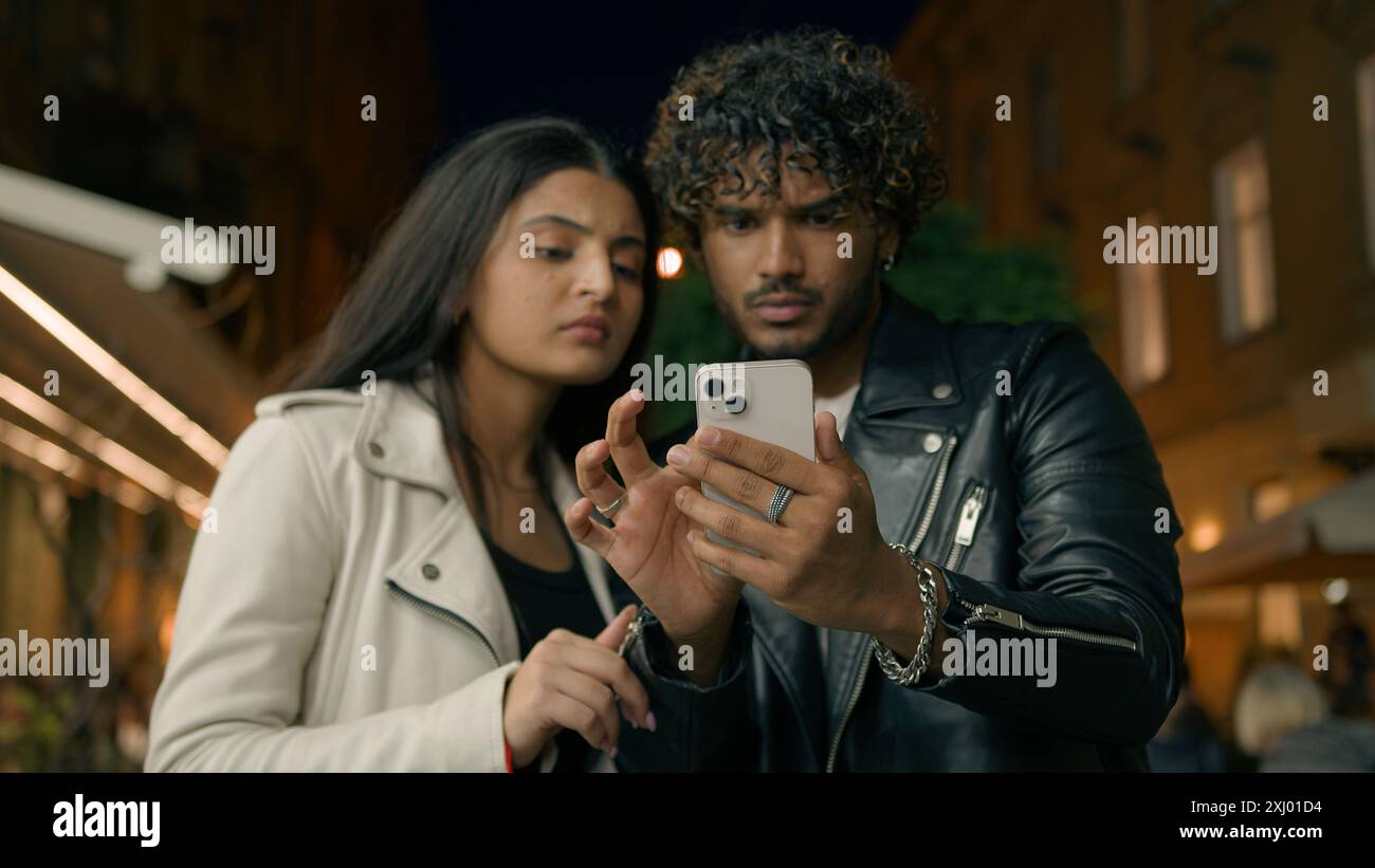 Uomo confuso donna ha perso la strada guardando direzione utilizzare la guida smartphone fidanzato fidanzata luna di miele vacanza turisti viaggiatori nella città serale di notte Foto Stock