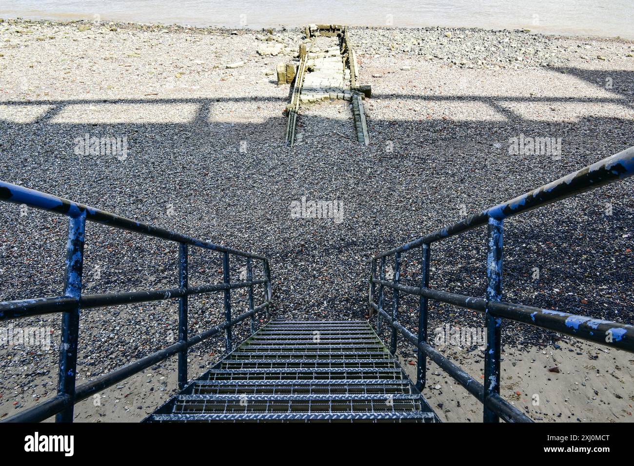 Scala di metallo fino alla spiaggia rocciosa e all'ex molo sul Tamigi durante la bassa marea, Londra, Inghilterra, Regno Unito Foto Stock