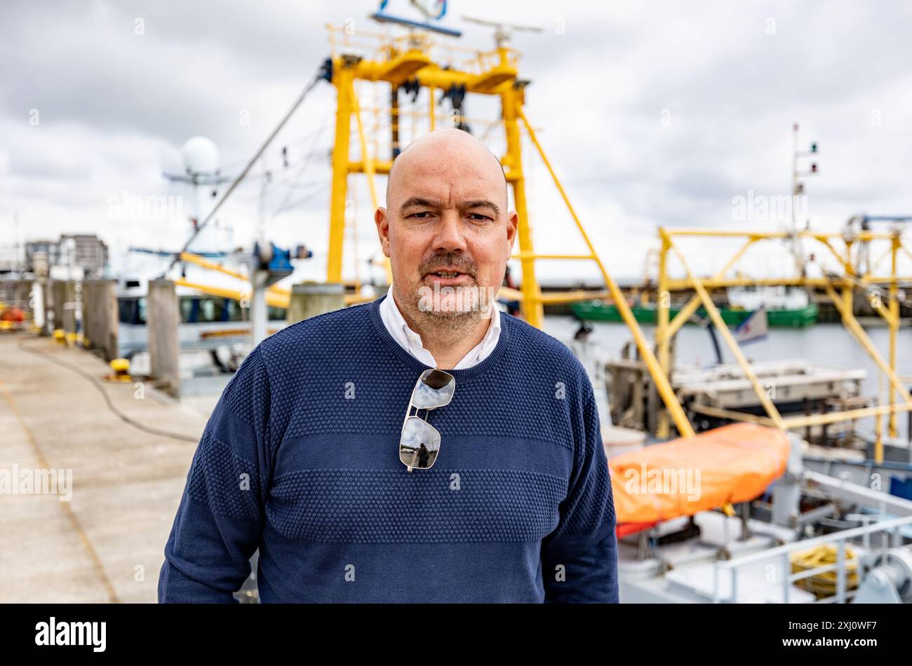 11 luglio 2024, Schleswig-Holstein, Hörnum (Sylt): Udo Hanrieder, sindaco, si trova di fronte ai pescherecci nel porto di Hörnum. La città di Hörnum ha costruito abitazioni per la gente del posto. (A dpa "spazio vitale scarso - come le isole lo trattano") foto: Axel Heimken/dpa Foto Stock