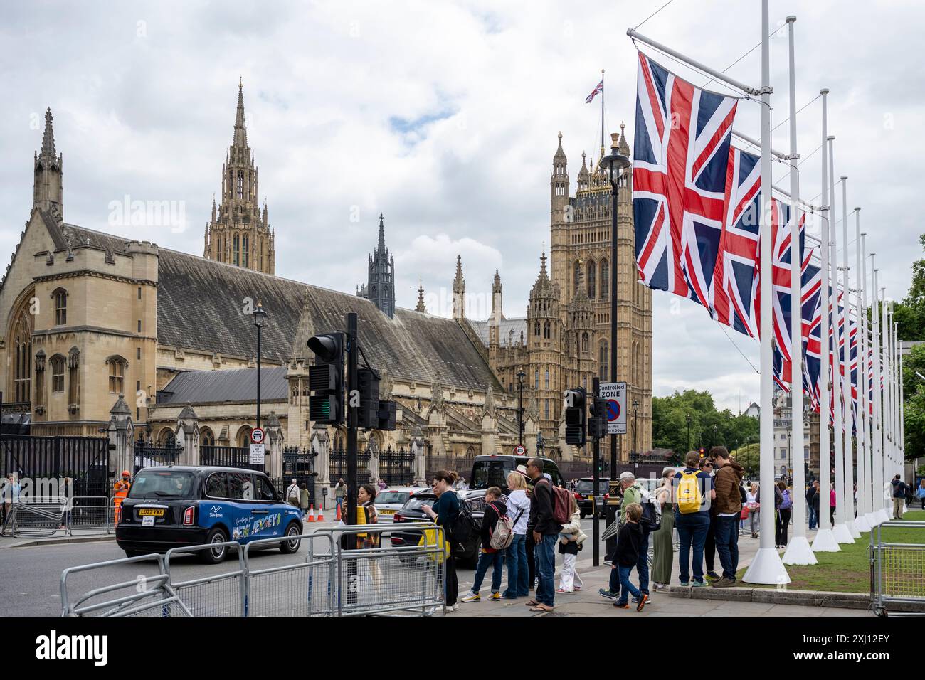 Londra, Regno Unito. 16 luglio 2024. Le bandiere dell’Unione sono state installate di fronte alle camere del Parlamento prima dell’apertura del Parlamento di domani, evento cerimoniale che segna formalmente l’inizio di ogni sessione del Parlamento del Regno Unito. Re Carlo pronuncerà il discorso del re, scritto dal nuovo governo laburista, dando notizia delle prossime visite di stato, e il programma legislativo del governo per la nuova sessione parlamentare. Solo dopo che il discorso del re è stato pronunciato può essere condotta qualsiasi attività parlamentare. Crediti: Stephen Chung / Alamy Live News Foto Stock