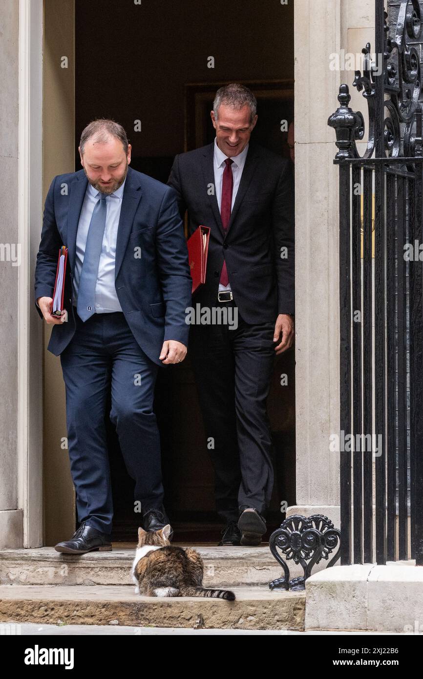 Londra, Regno Unito. 16 luglio 2024. Ian Murray MP (l), Segretario di Stato per la Scozia, e Peter Kyle MP (r), Segretario di Stato per la Scienza, l'innovazione e la tecnologia, avvicinano Larry il gatto mentre lasciano 10 Downing Street a seguito di una riunione del Gabinetto. Il primo ministro britannico Sir Keir Starmer ha comunicato che il suo nuovo governo deve "mettersi in moto” con particolare attenzione alla consegna. Crediti: Mark Kerrison/Alamy Live News Foto Stock