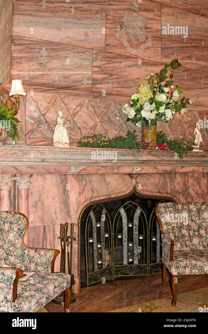 Camino in marmo rosa, insolito, 2 sedie, parafiamma con candele, fiori e verdi sul mantello, statue, ex Pott's Mansion, Langoma, 1897, histori Foto Stock
