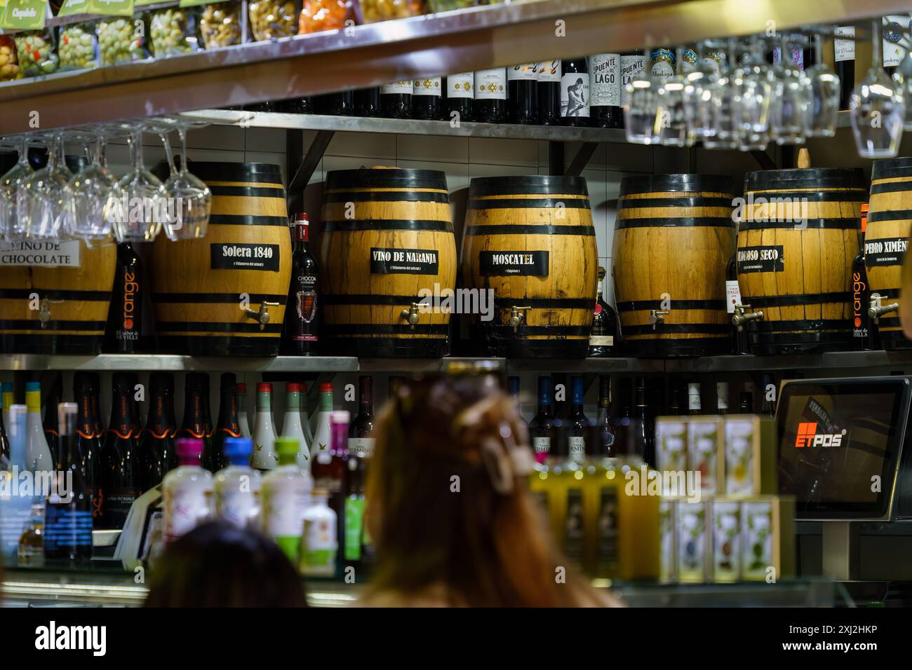 Siviglia, Spagna. 5 febbraio 2024 - botti di vino di legno dietro un bancone a mercado de triana Foto Stock