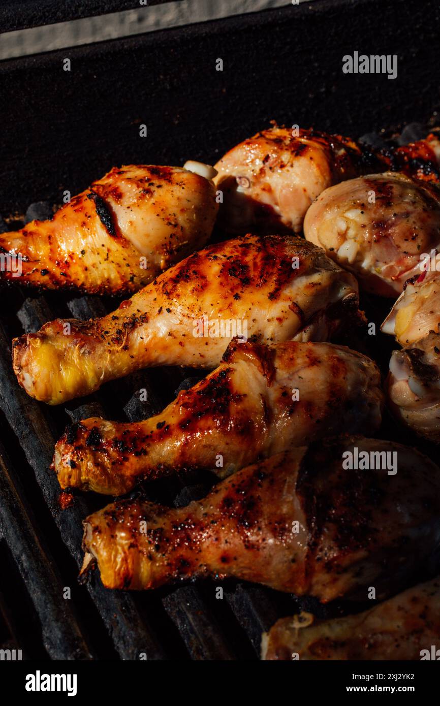 primo piano di sei cosce di pollo grigliate al barbecue al sole Foto Stock