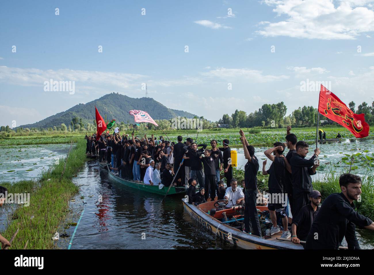 Srinagar, India. 16 luglio 2024. I lori sciiti del Kashmir si spostano in barca durante la processione negli interni del lago dal a Srinagar il 9 di Muharram, il primo e più santo mese del calendario islamico. I musulmani sciiti commemorano Muharram come un mese di lutto in ricordo del martirio del nipote del profeta islamico Imam Hussain, che è stato ucciso insieme ai suoi familiari ad Ashura (il decimo giorno di Muharram) nella battaglia di Karbala nel sud dell'Iraq nel 680 d.C. (foto di Faisal Bashir/SOPA Images/Sipa USA) crediti: SIPA USA/Alamy Live News Foto Stock