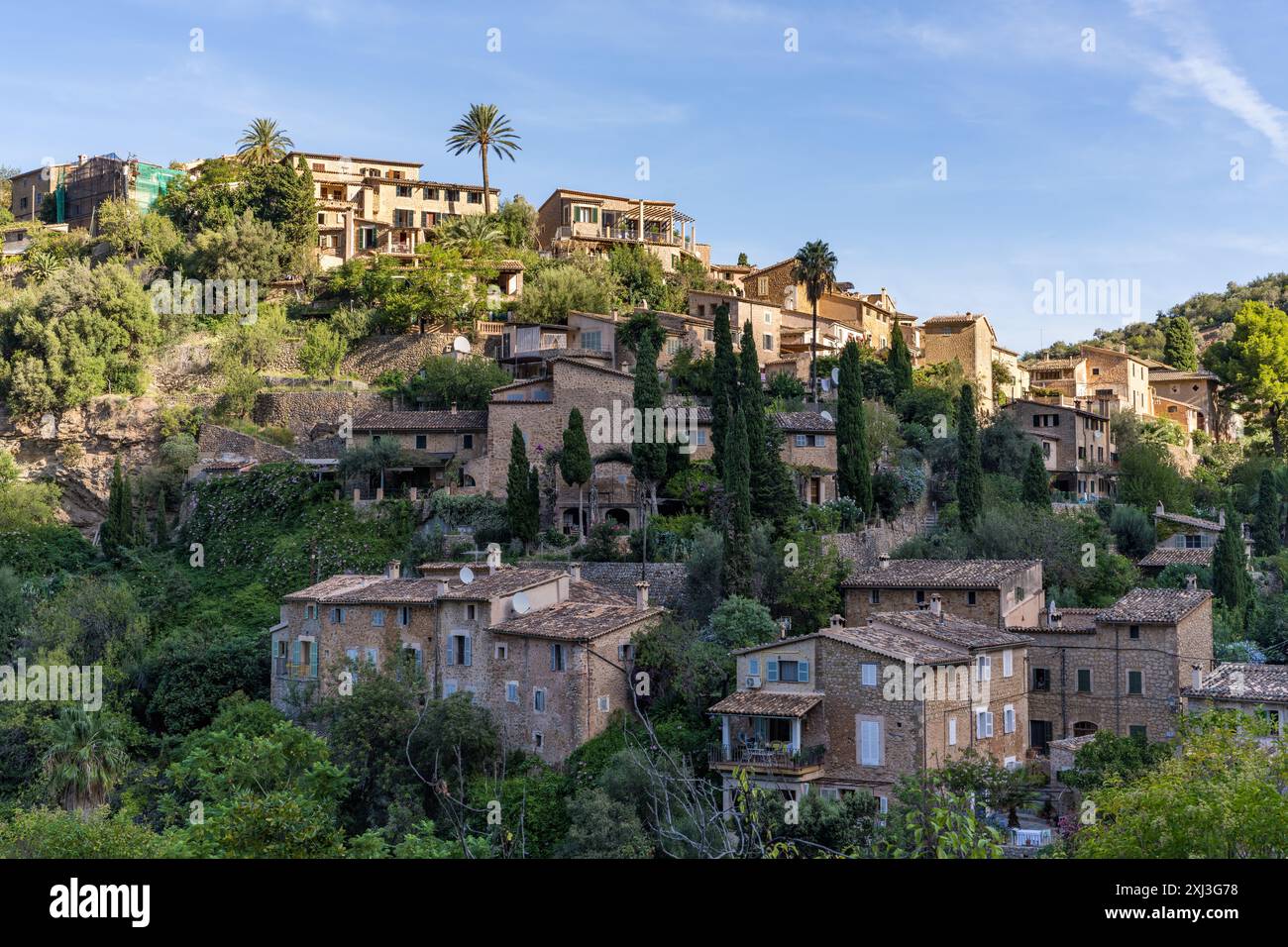 Paesaggio mozzafiato del piccolo borgo costiero Deia a Mallorca, Spagna. Case tradizionali in terrazze sulle colline circondata da verdi alberi Foto Stock