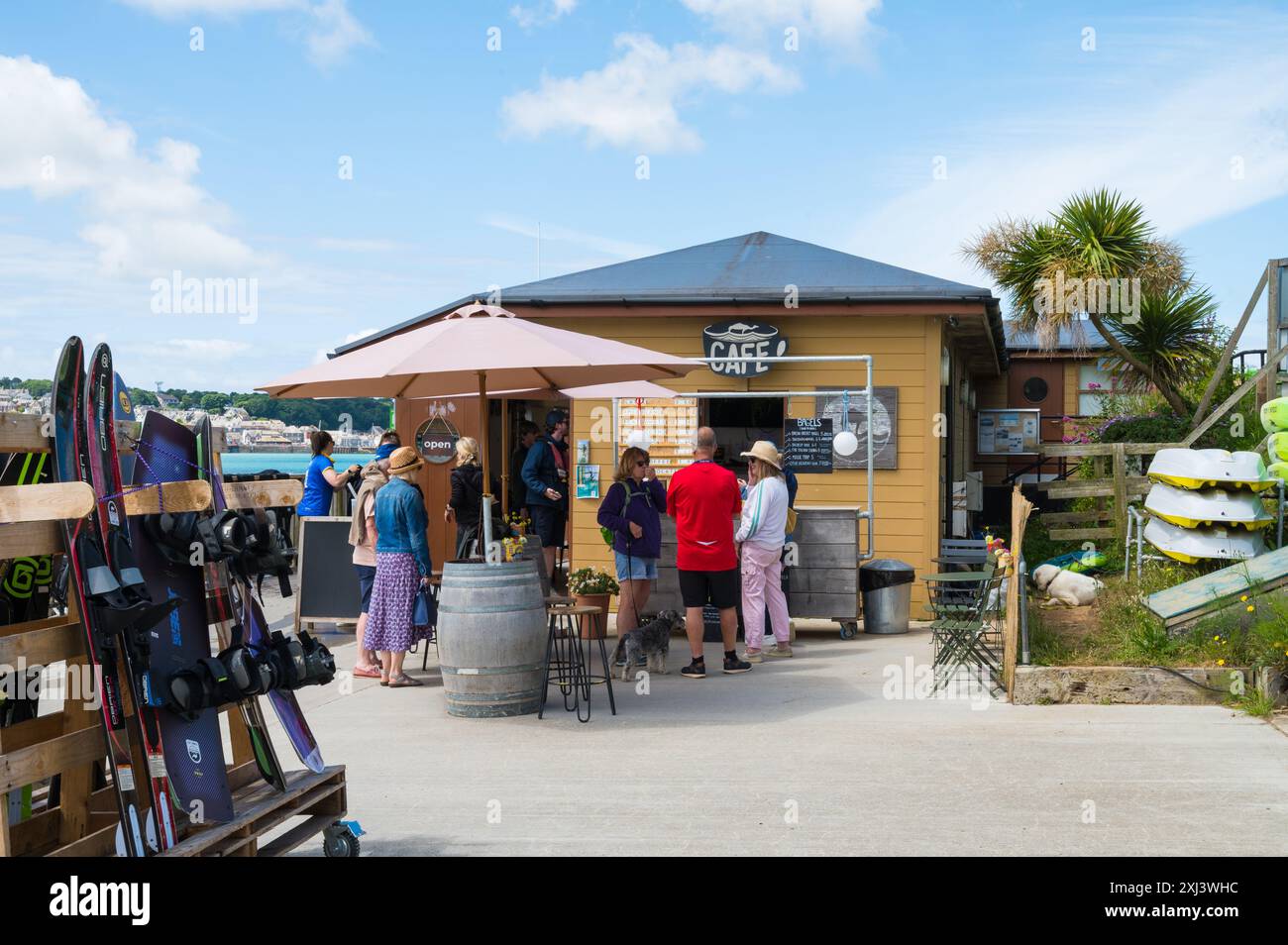 Persone che acquistano rinfreschi presso la Camel Ski School Camel Ski Cafe, caffetteria sul lungomare di Rock, Cornovaglia, Inghilterra, Regno Unito Foto Stock