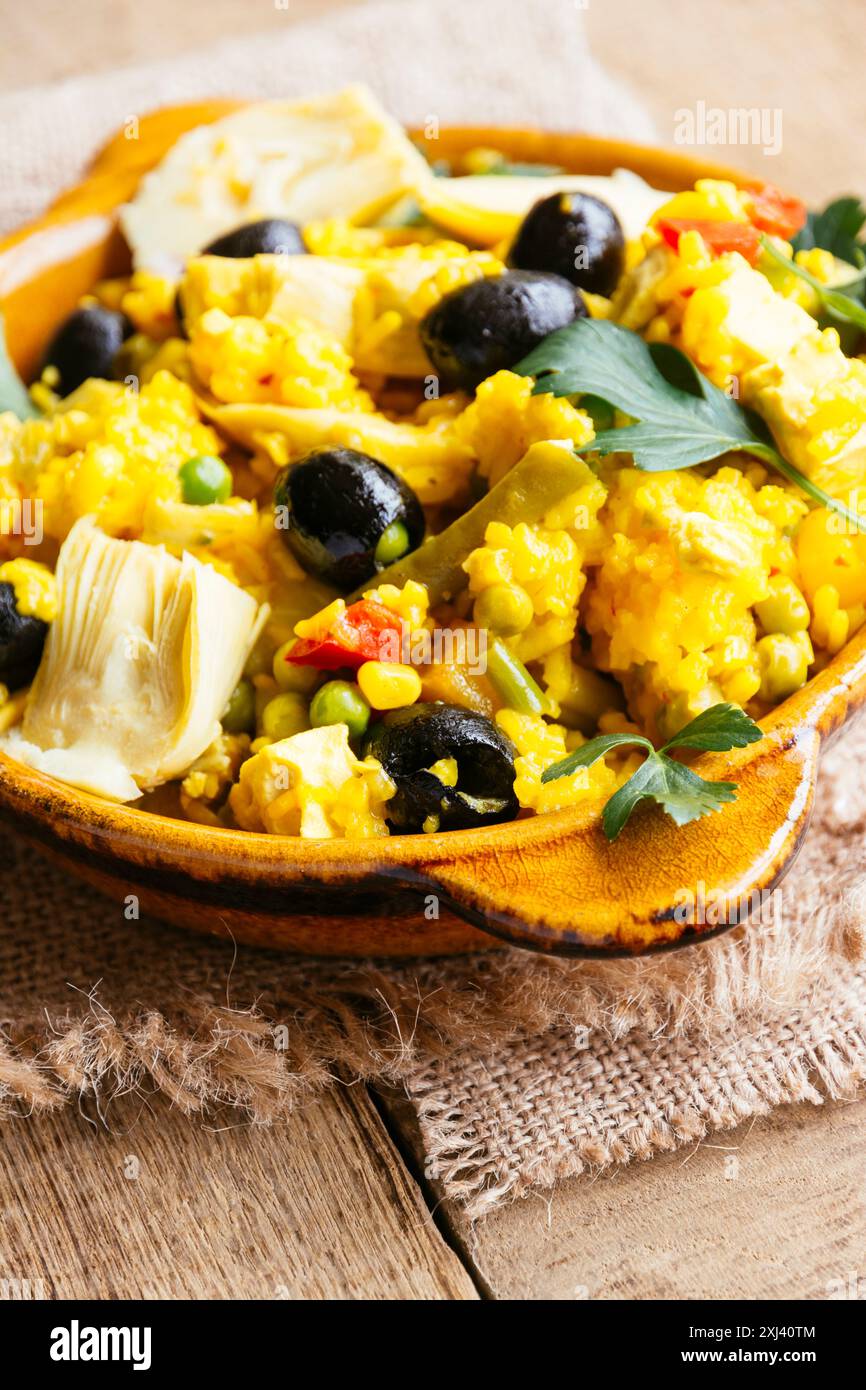 Paella vegetariana con carciofi, olive nere, fagioli verdi e il peperone rosso Foto Stock