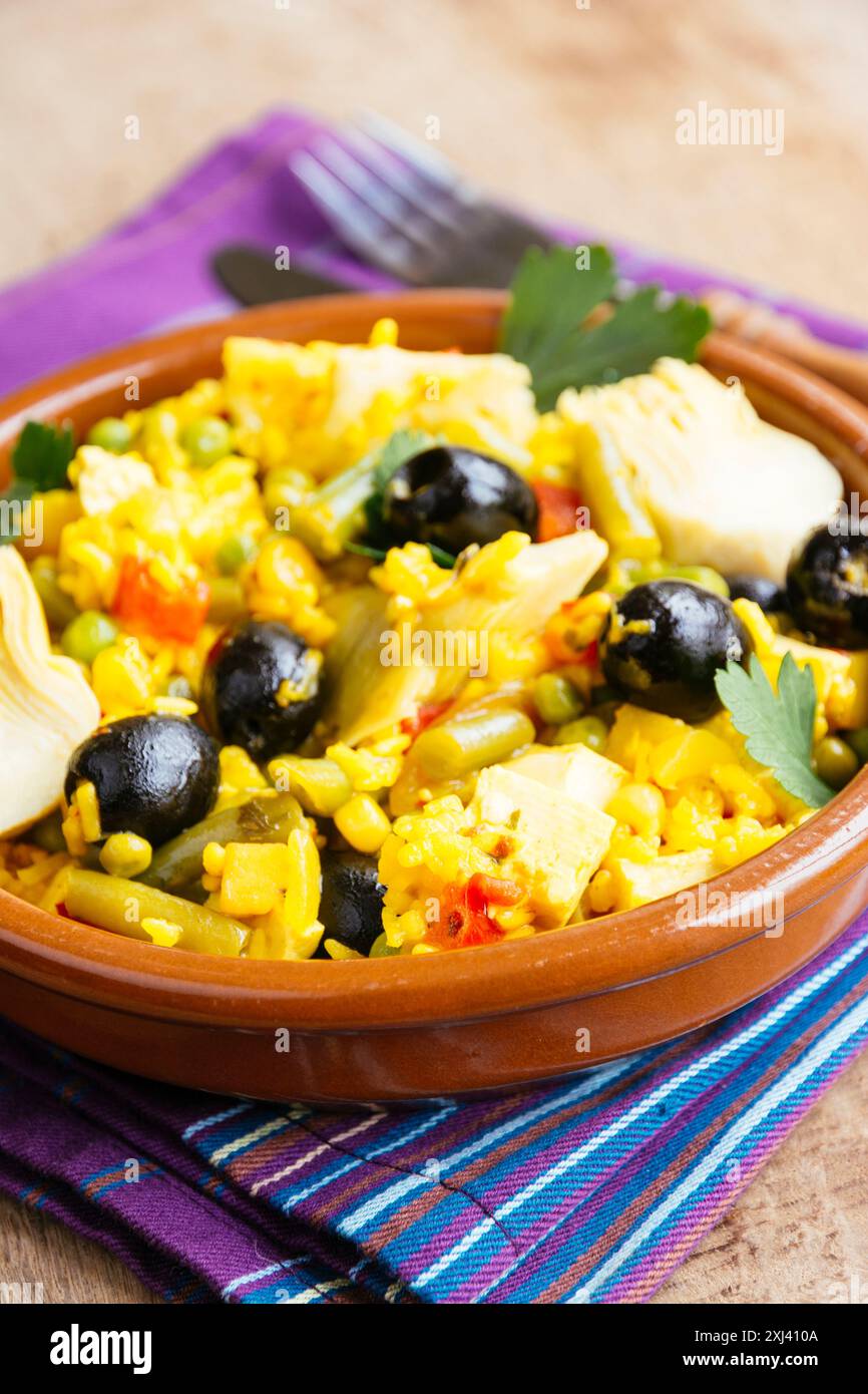 Paella vegetariana con carciofo, olive nere, fagioli verdi e peperone rosso. Foto Stock