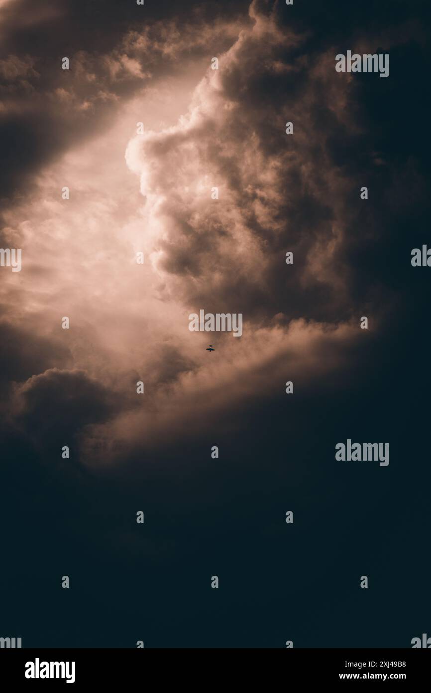 Cielo cinematografico con ombre profonde. Un piccolo aereo nel mezzo. Colori caldi per un effetto nostalgico. Foto Stock