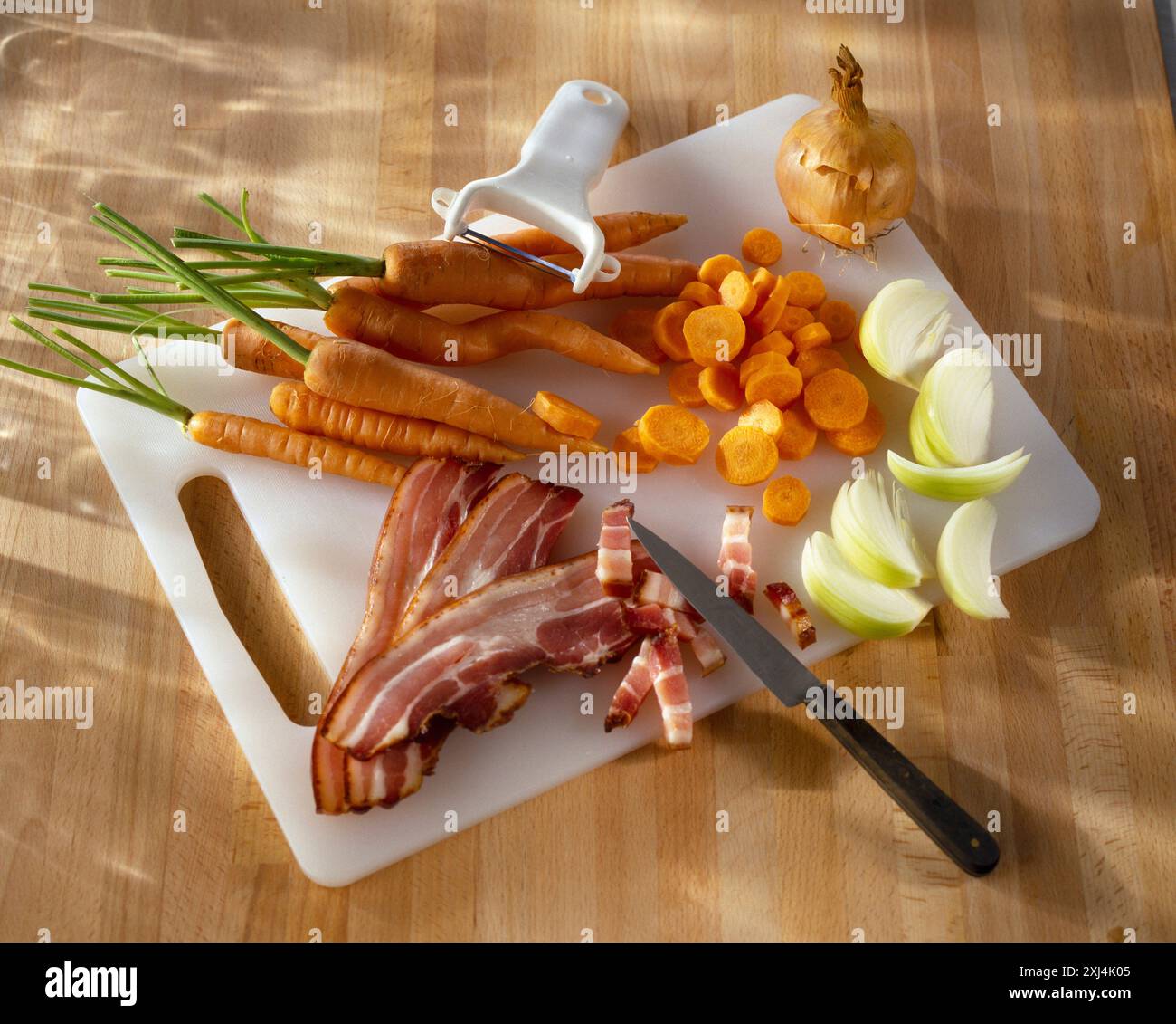 Tagliare a cubetti la pancetta e affettare le verdure Foto Stock