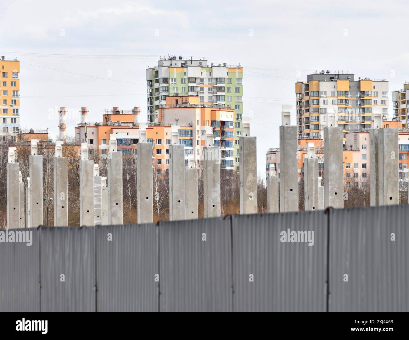 Pali di cemento sullo sfondo di nuovi edifici Foto Stock