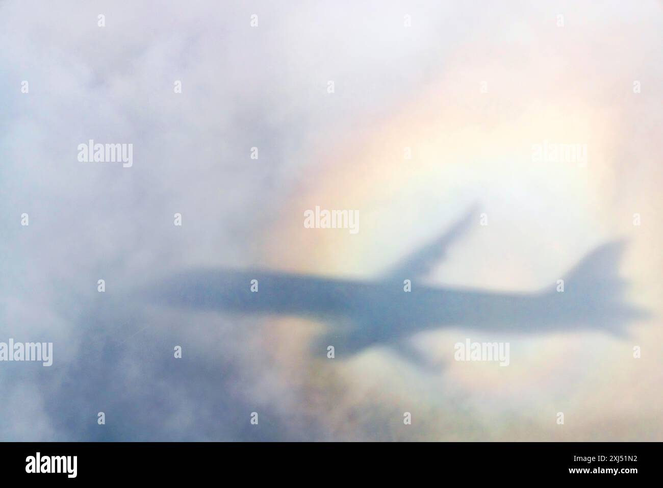 Un aereo proietta un'ombra su una nuvola, una silhouette e un arcobaleno alone. Germania Foto Stock