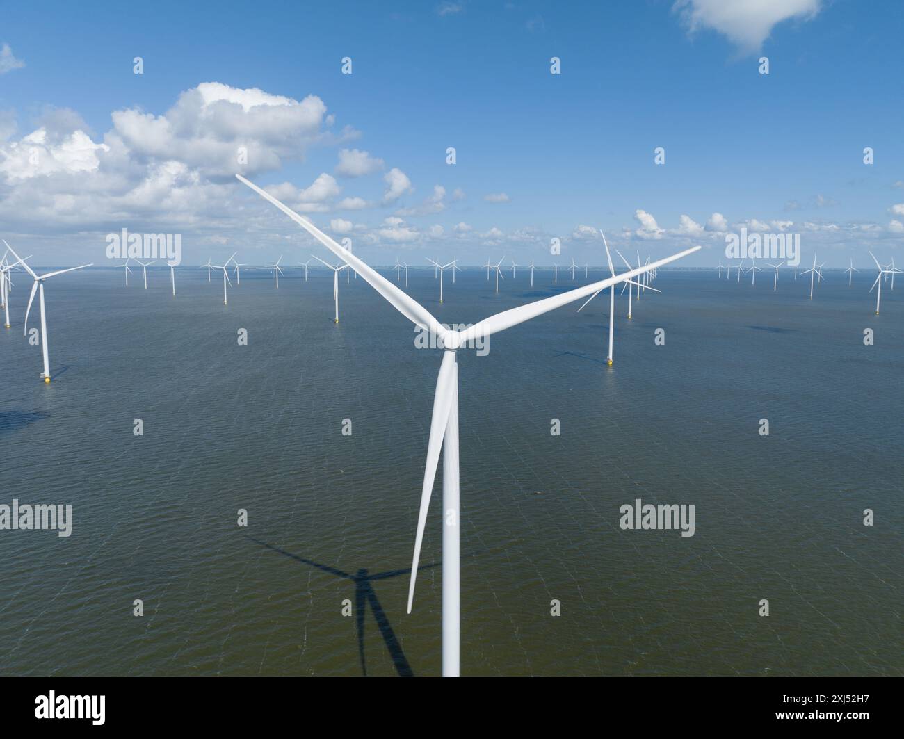 Turbine eoliche sull'acqua. Soluzione per il cambiamento climatico, energia verde e sostenibile dal vento. Vista aerea. Foto Stock