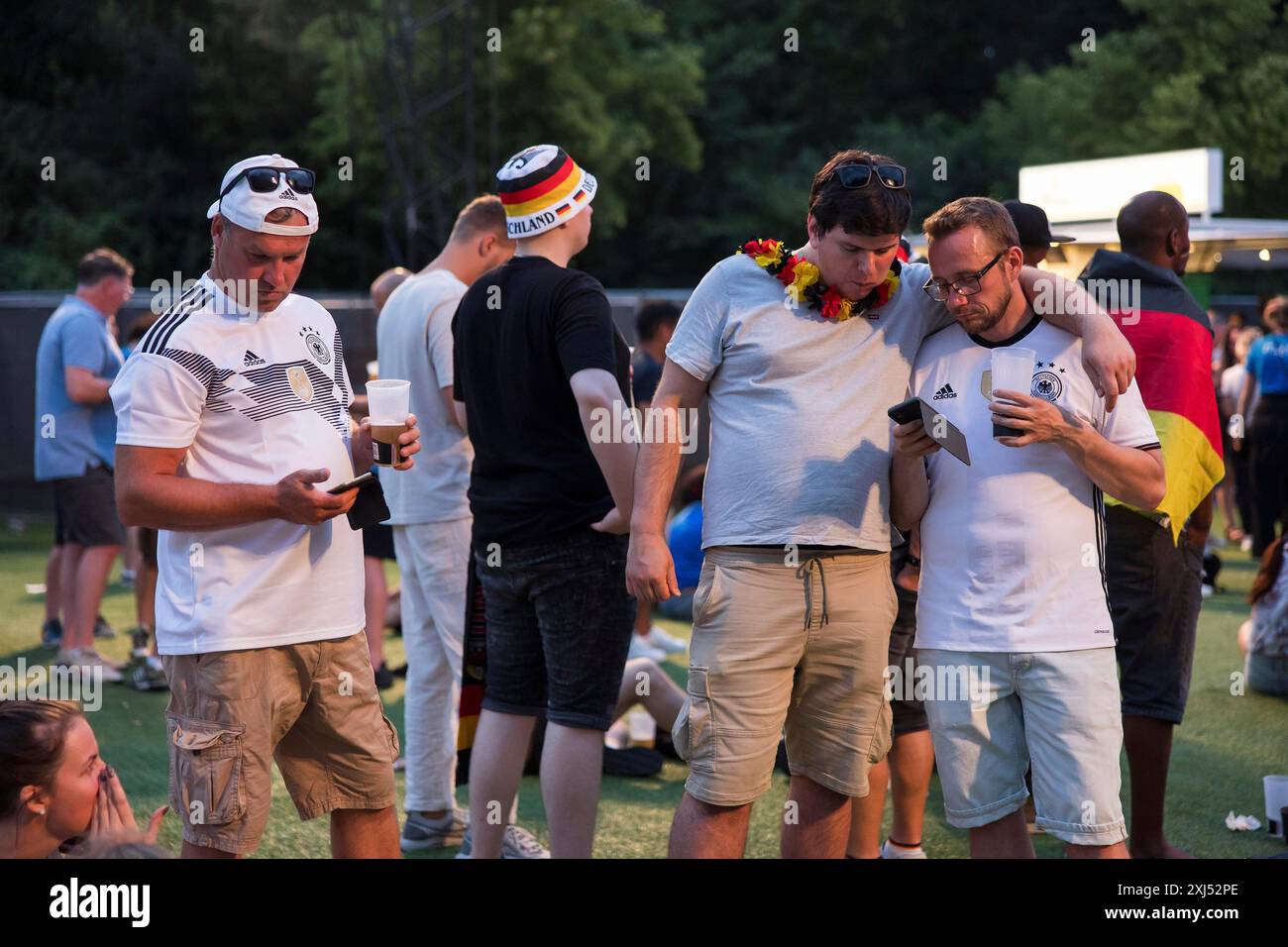 I tifosi di Fassball festeggiano e raccolgono informazioni nella zona tifosi del Brandenburg Tor dopo l'interruzione del turno di 16 partite tra la Germania Foto Stock