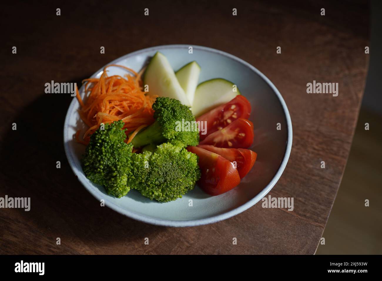 spuntino crudo in una ciotola azzurra (carote, broccoli, zucchine, pomodori) Foto Stock