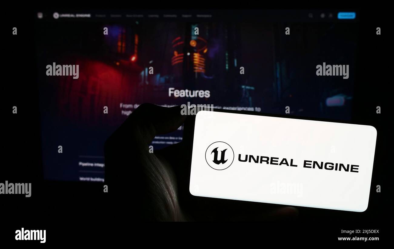 Stoccarda, Germania, 02-12-2024: Persona che tiene il cellulare con il logo del software di gioco 3D Unreal Engine (Epic Games) davanti alla pagina web aziendale. Concentrati Foto Stock