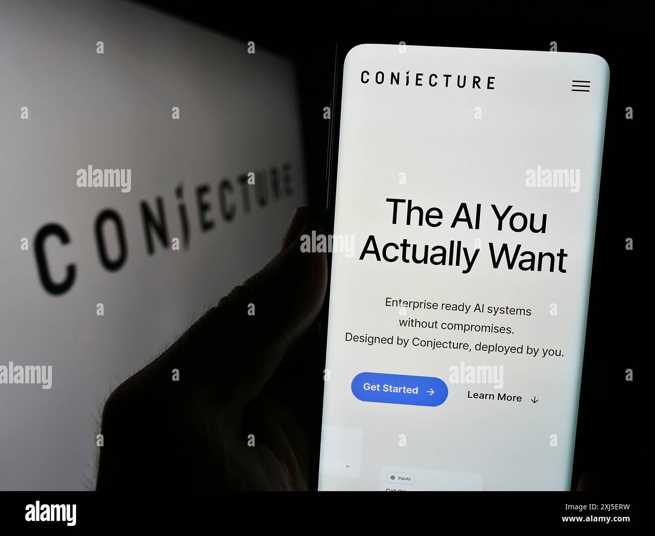 Stoccarda, Germania, 02-19-2024: Persona che detiene il cellulare con pagina web della società britannica di intelligenza artificiale Conjecture Limited con logo. Concentrati Foto Stock