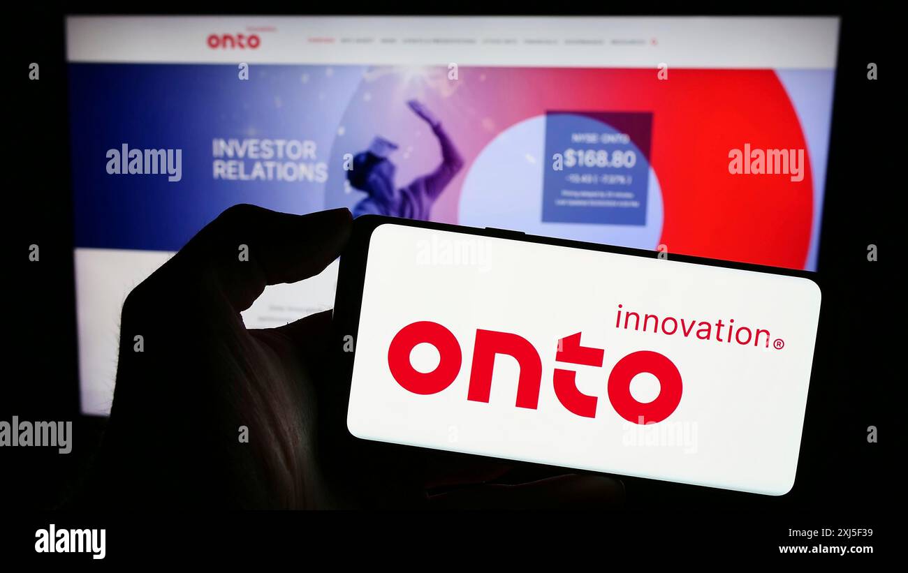 Stuttgart, Germania, 02-21-2024: Persona che detiene uno smartphone con il logo della società statunitense di semiconduttori su Innovation Inc. Di fronte al sito Web. Concentrati su Foto Stock